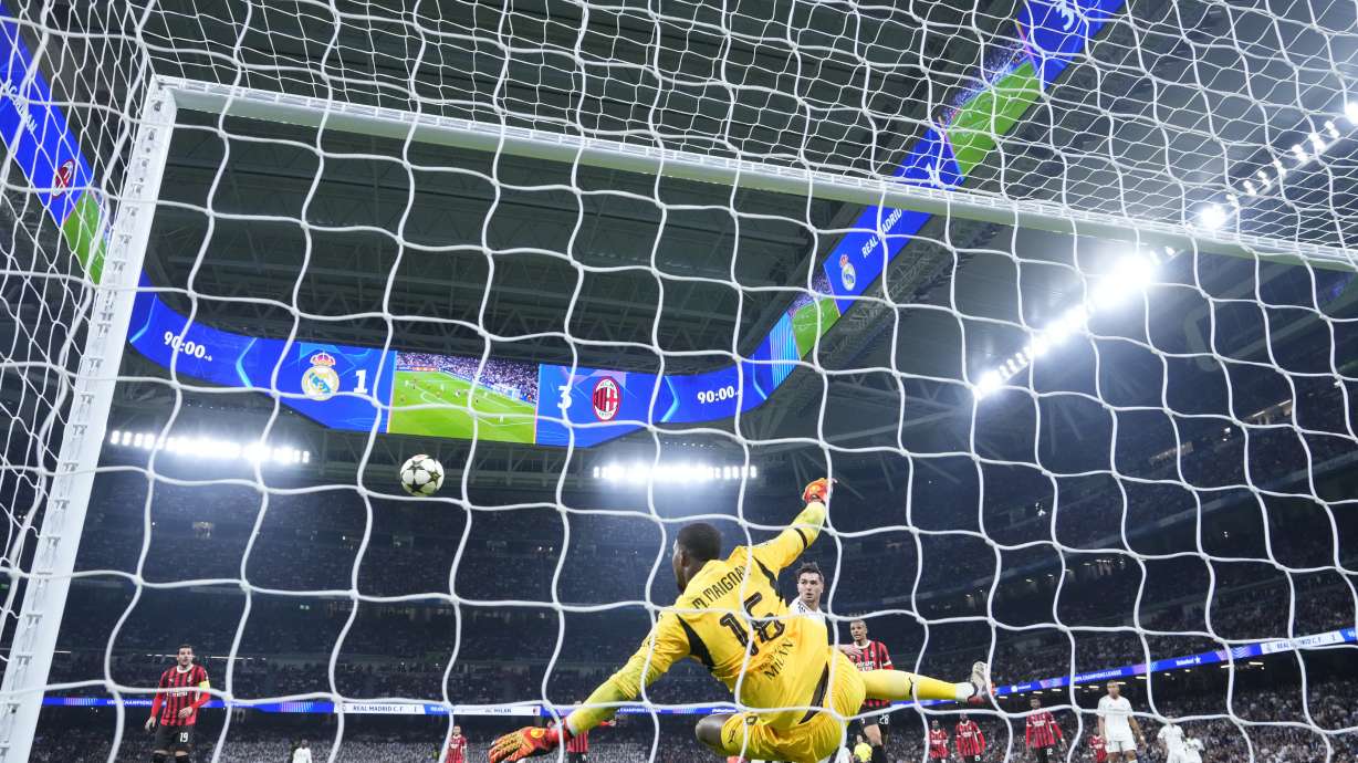 AC Milan's goalkeeper Mike Maignan stops a ball during the Champions League opening phase soccer match against Real Madrid at the Santiago Bernabeu stadium in Madrid, Spain, Tuesday, Nov. 5, 2024.