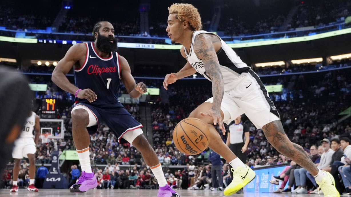 San Antonio Spurs forward Jeremy Sochan, right, drives past Los Angeles Clippers guard James Harden during the first half of an NBA basketball game, Monday, Nov. 4, 2024, in Inglewood, Calif.
