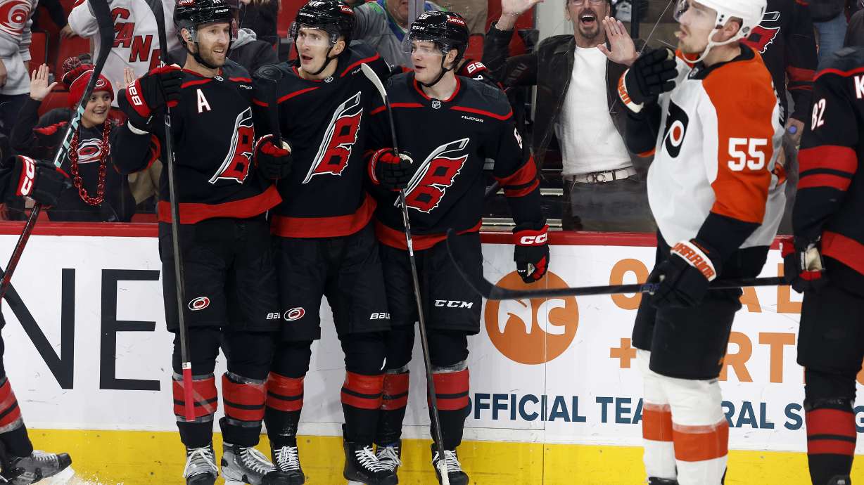 Carolina Hurricanes' Jaccob Slavin, left, Martin Necas, congratulate Eric Robinson, right, on his goal as Philadelphia Flyers' Rasmus Ristolainen (55) during the second period of an NHL hockey game in Raleigh, N.C., Tuesday, Nov. 5, 2024.