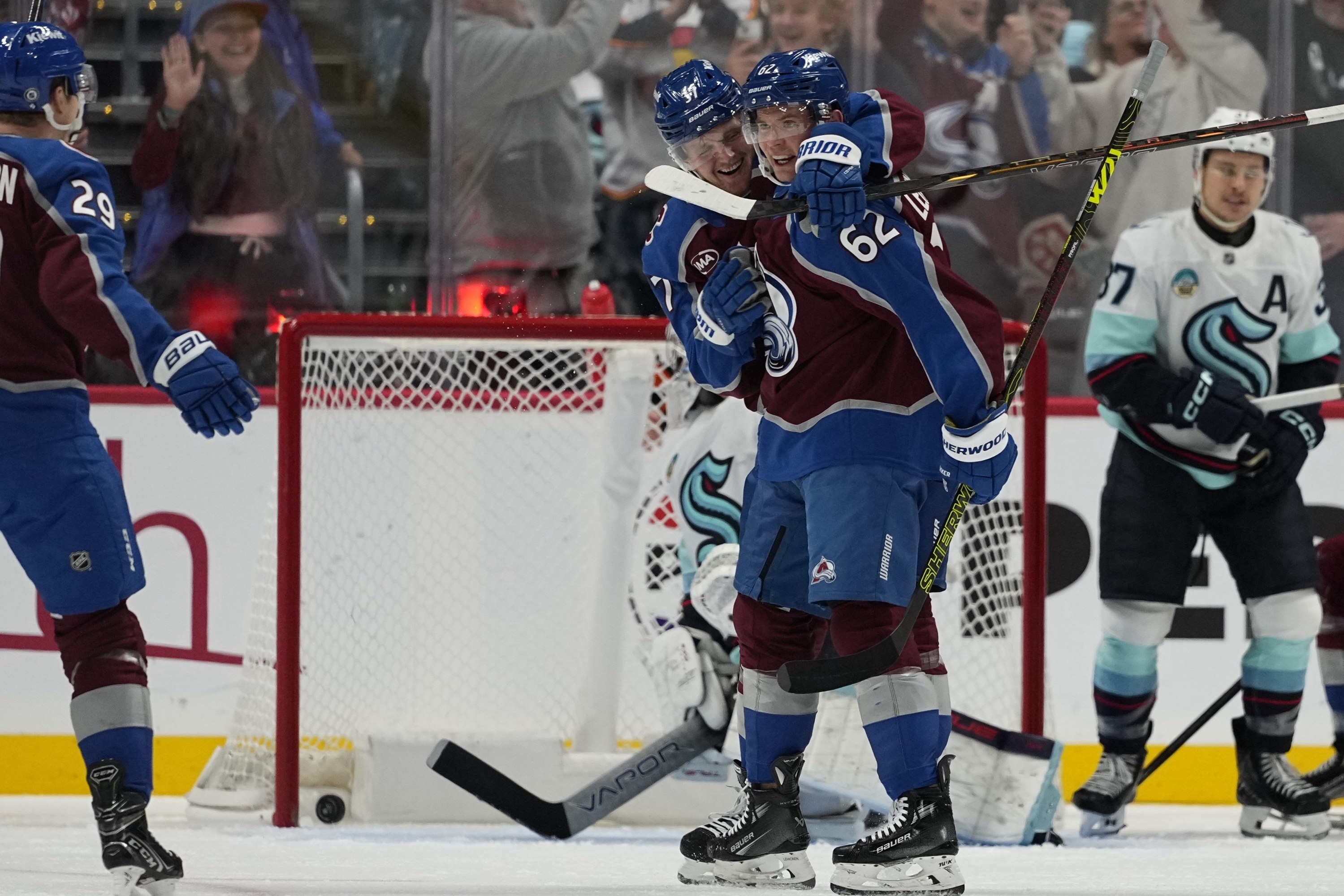 Colorado Avalanche left wing Artturi Lehkonen (62) is congratulated by teammate Casey Mittelstadt (37) after scoring a goal against the Seattle Kraken during the second period of an NHL hockey game Tuesday, Nov. 5, 2024, in Denver.