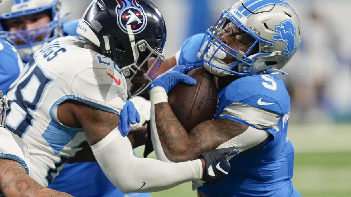 Detroit Lions running back David Montgomery (5) runs the ball against Tennessee Titans safety Quandre Diggs (28) during the first half of an NFL football game Sunday, Oct. 27, 2024, in Detroit.