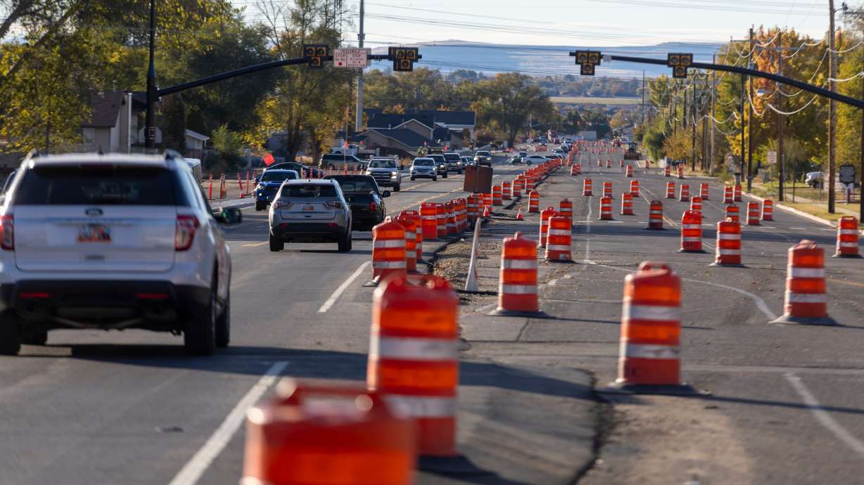 Cars pass orange cones and construction equipment during a major Utah Department of Transportation project in Roy on Monday.