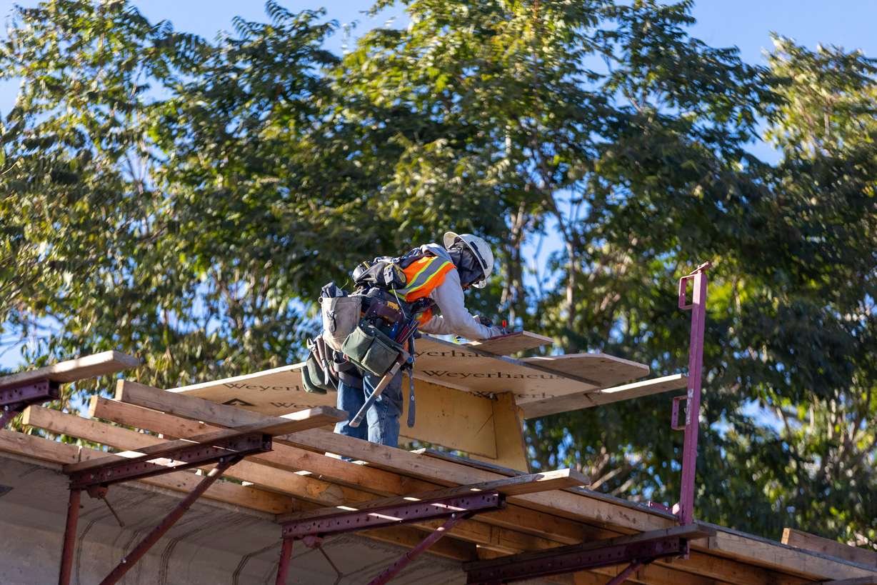 A construction worker works on a pedestrian bridge that is part of a major Utah Department of Transportation project in Roy on Monday.