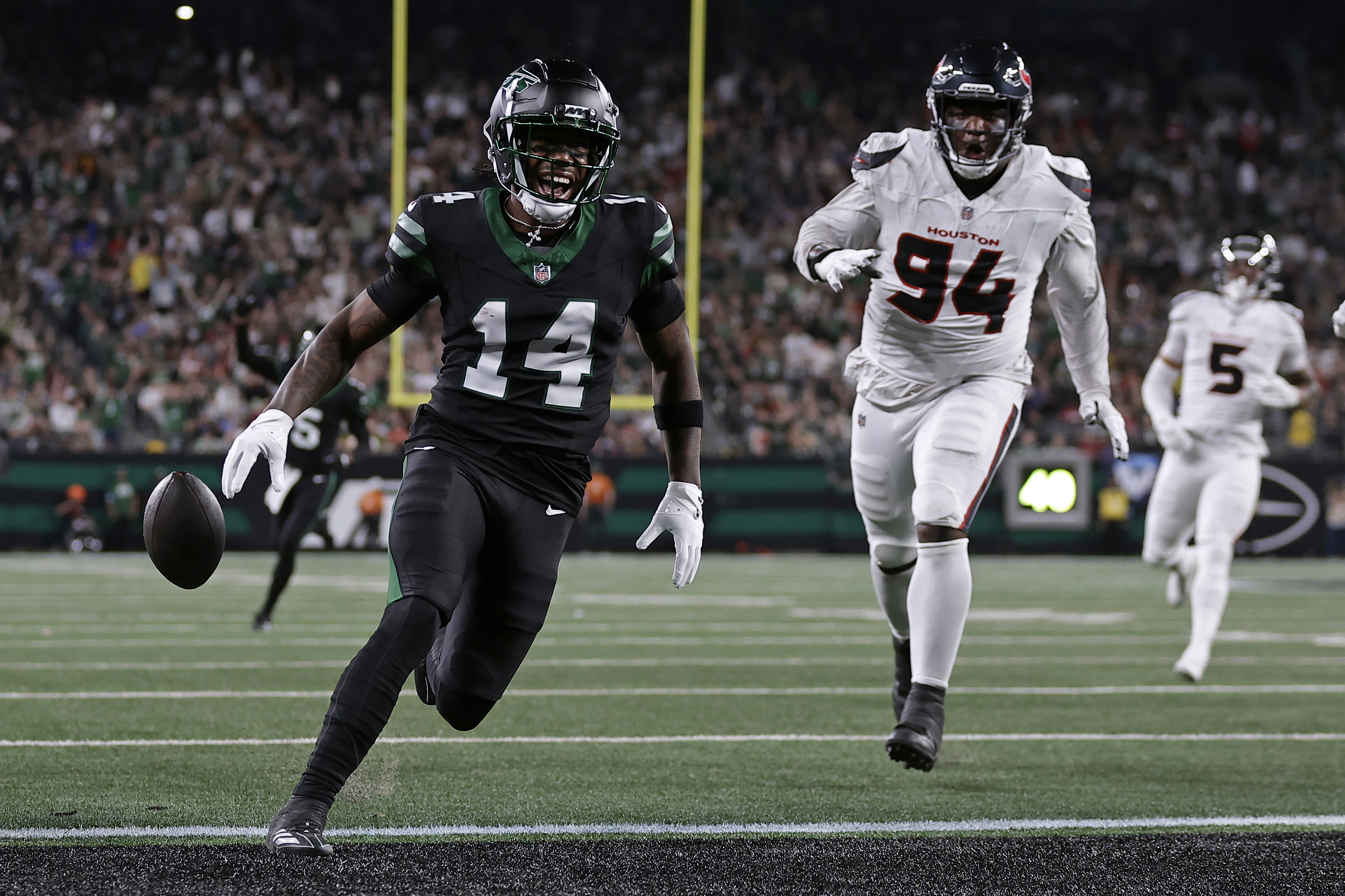 New York Jets wide receiver Malachi Corley (14) drops the ball short of the goal line in front of Houston Texans defensive tackle Khalil Davis (94) during an NFL football game Thursday, Oct. 31, 2024, in East Rutherford, N.J.