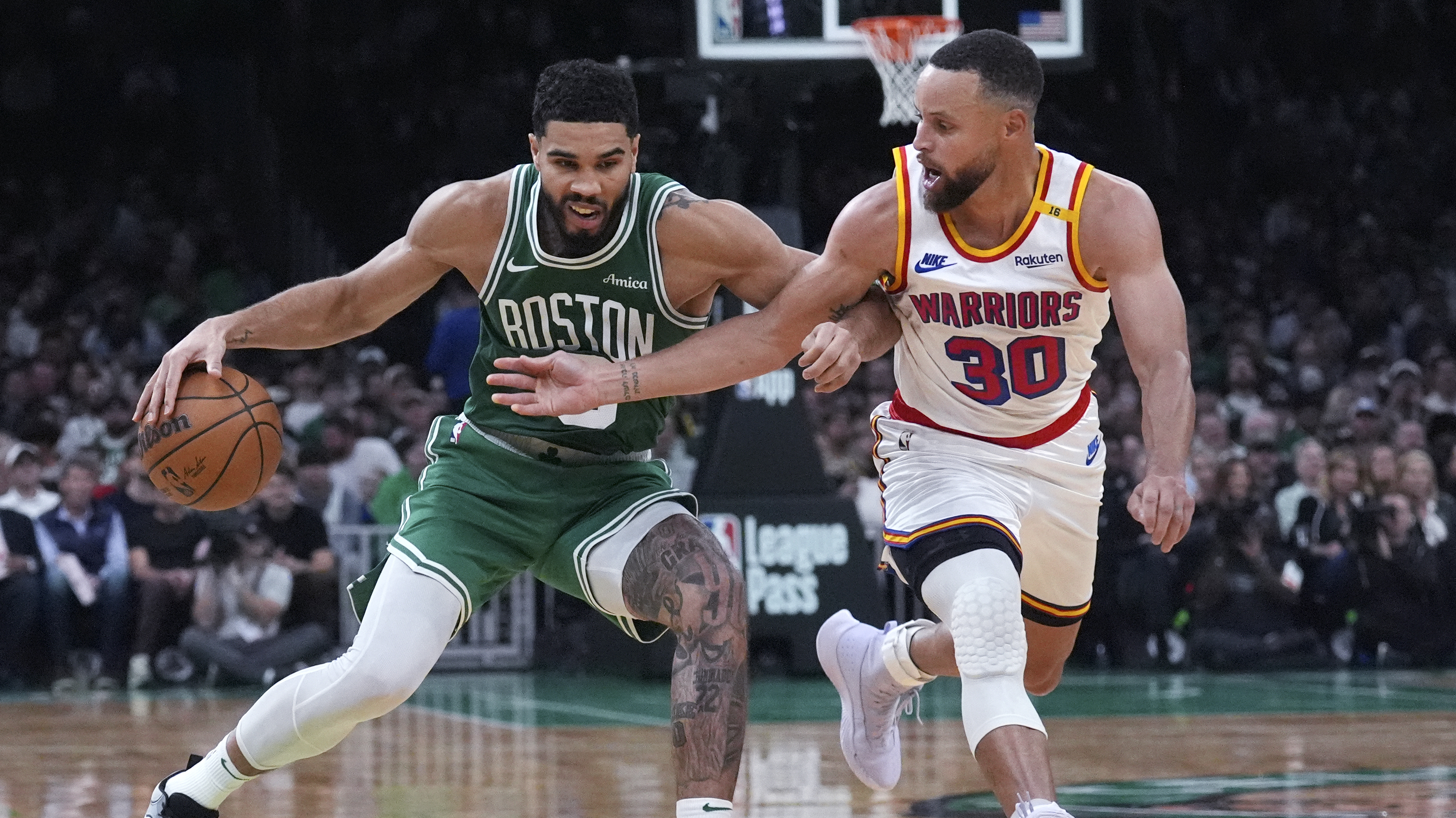 Boston Celtics forward Jayson Tatum, left, drives to the basket against Golden State Warriors guard Stephen Curry during the second half of an NBA basketball game, Wednesday, Nov. 6, 2024, in Boston.