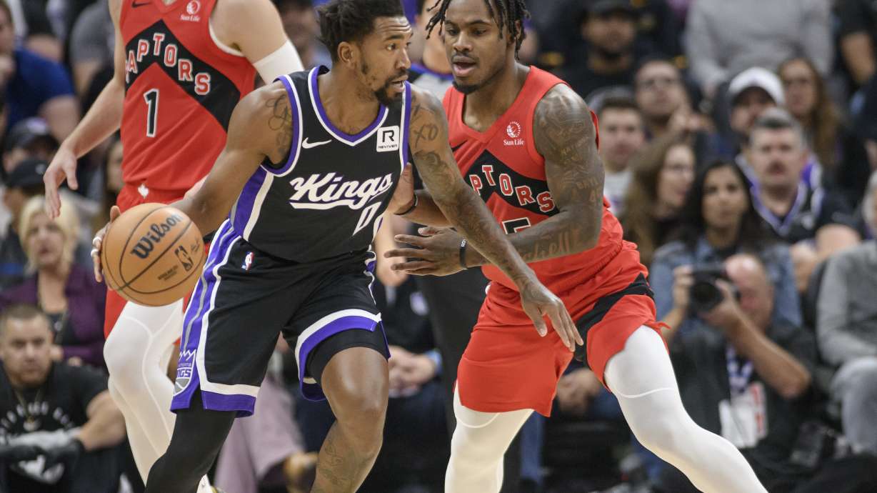 Sacramento Kings guard Malik Monk (0) is guarded by Toronto Raptors guard Davion Mitchell during the first half of an NBA basketball game in Sacramento, Calif., Wednesday, Nov. 6, 2024.