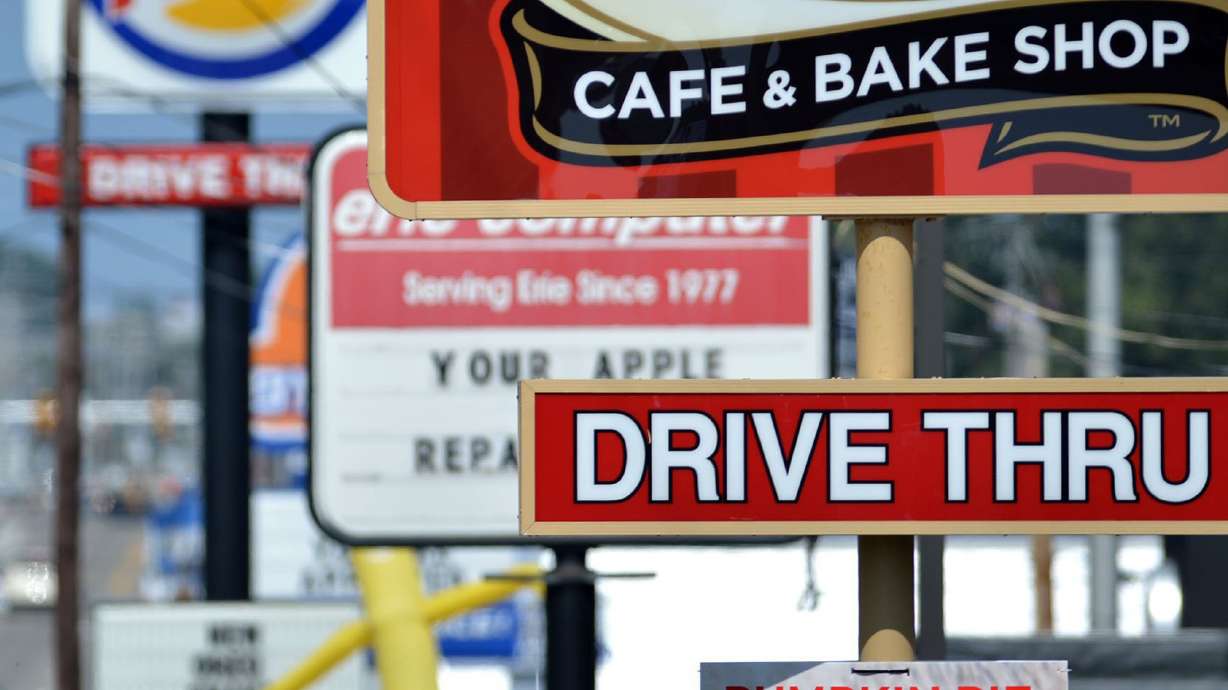 Fast-food restaurant signs line Peach Street in Erie, Pa. While prices for most goods have been falling throughout the year, inflation for a wide range of services, including restaurants, remains high.