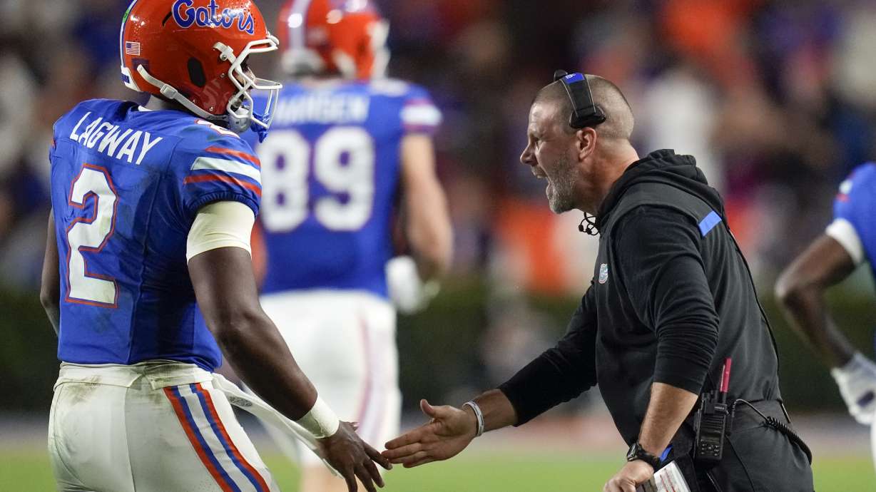 Florida head coach Billy Napier, right, greets quarterback DJ Lagway (2) as he comes off the field during the first half of an NCAA college football game against Kentucky, Saturday, Oct. 19, 2024, in Gainesville, Fla.