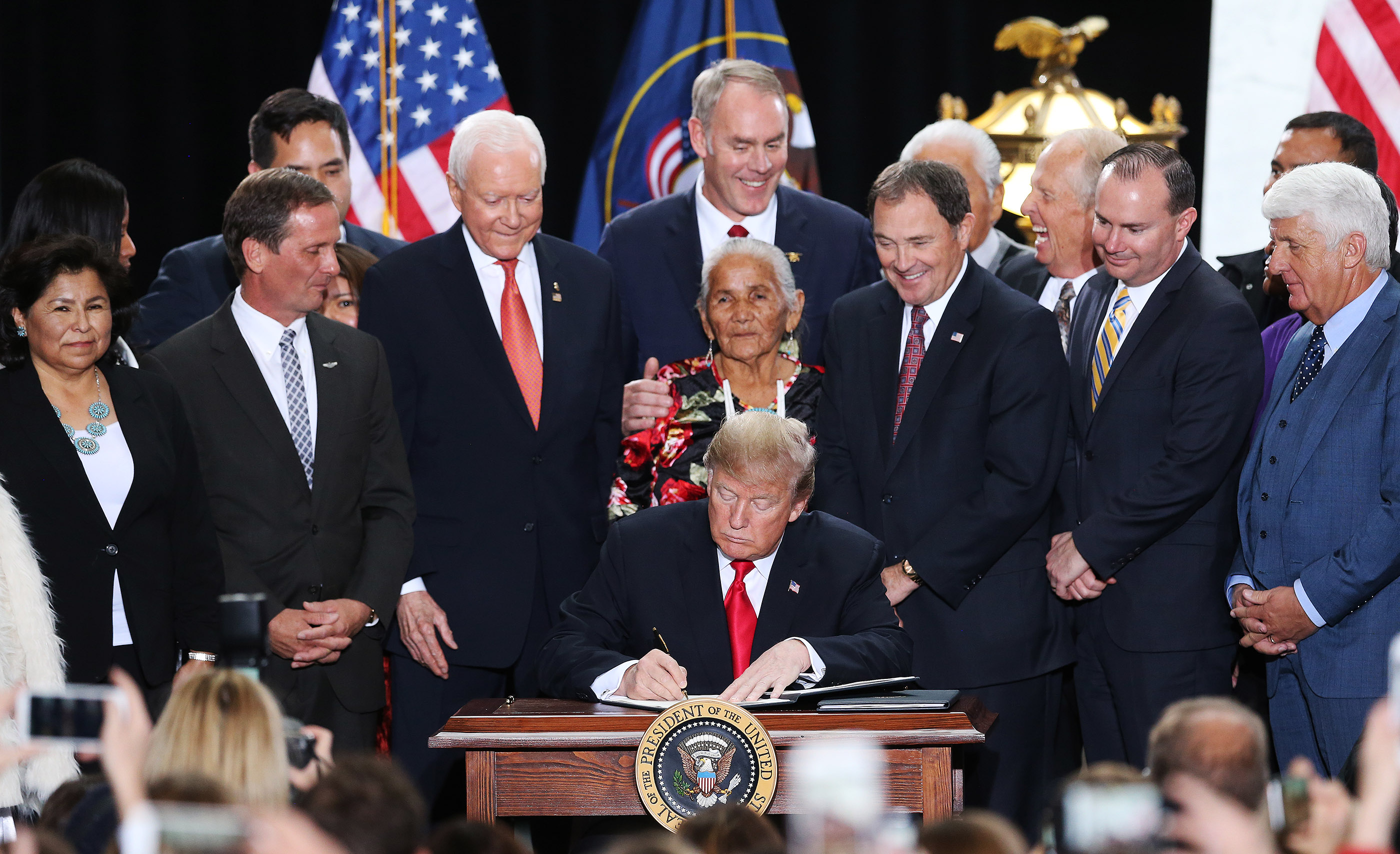 President Donald Trump, center, signs proclamations to scale back Bears Ears and Grand Staircase-Escalante national monuments at the Capitol in Salt Lake City on Dec. 4, 2017, as local and national leaders look on.