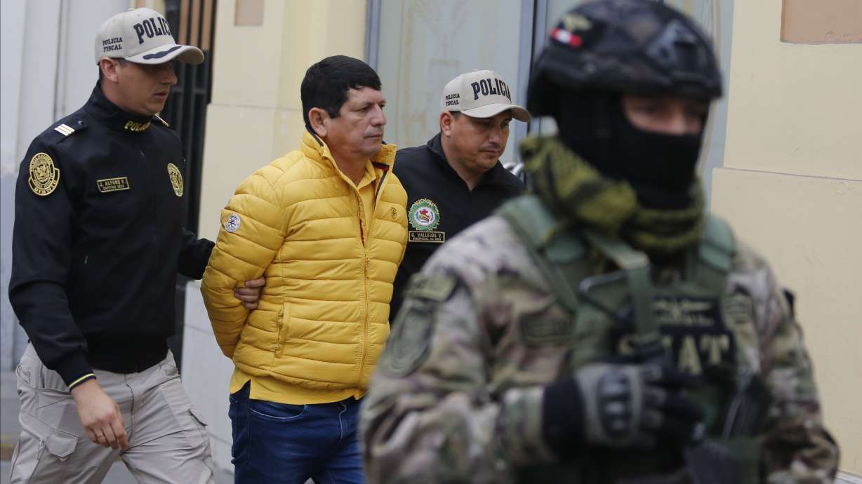 Police escort Agustin Lozano, head of Peru's soccer federation, after arresting him as part of an investigation into fraud, extortion and money laundering in Lima, Peru, Thursday, Nov. 7, 2024.