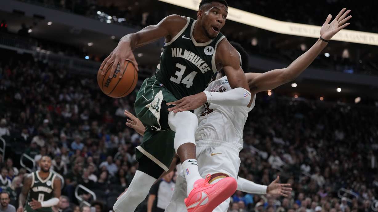 Milwaukee Bucks' Giannis Antetokounmpo passes to Damian Lillard in front of Cleveland Cavaliers' Jarrett Allen during the first half of an NBA basketball game Saturday, Nov. 2, 2024, in Milwaukee.