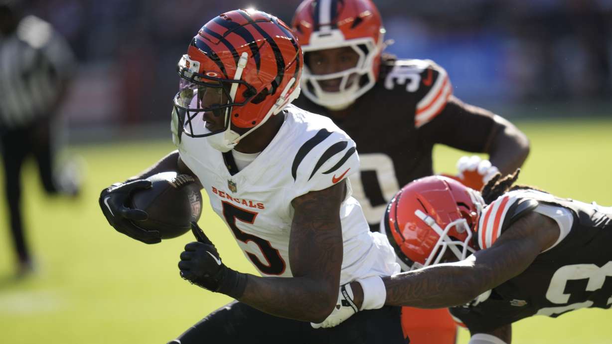 Cincinnati Bengals wide receiver Tee Higgins (5) carries against Cleveland Browns cornerback Martin Emerson Jr. (23) in the second half of an NFL football game, Sunday, Oct. 20, 2024, in Cleveland.