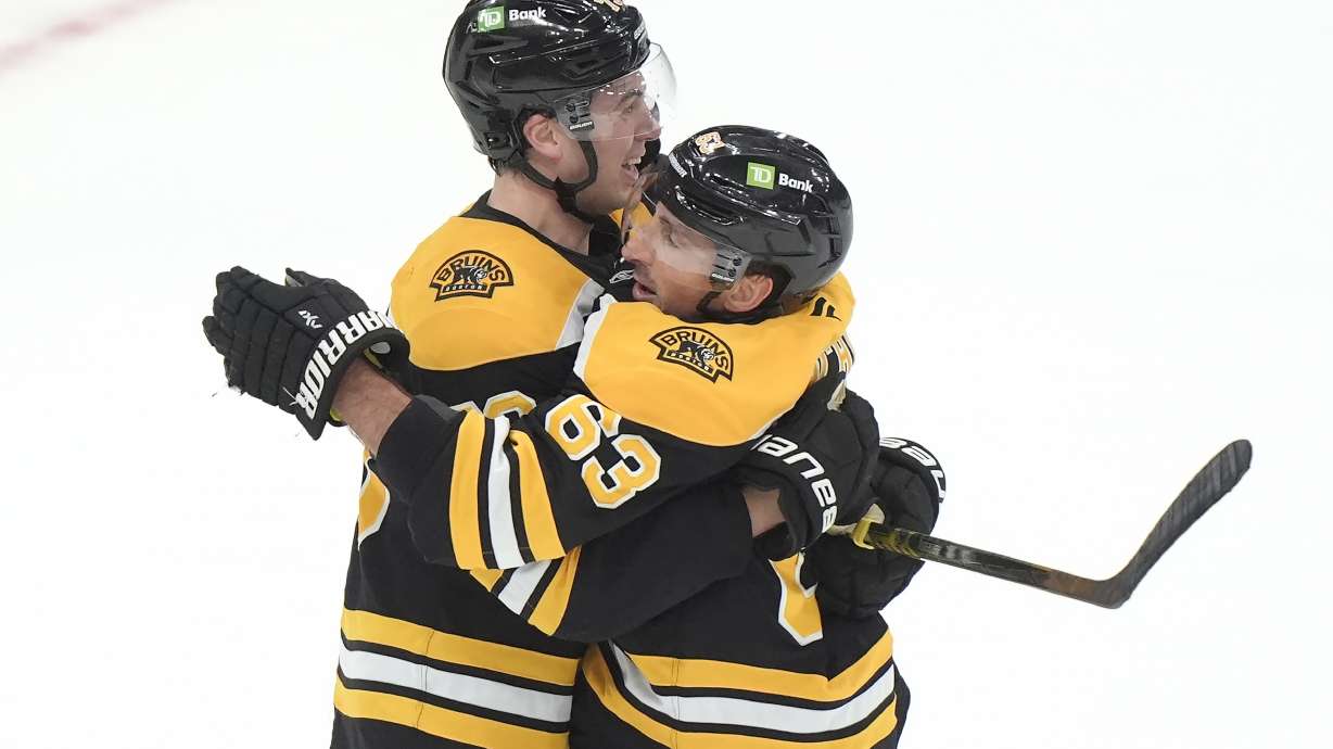Boston Bruins left wing Brad Marchand, right, celebrates his goal with defenseman Charlie McAvoy, left, after scoring in overtime to end an NHL hockey game against the Calgary Flames, Thursday, Nov. 7, 2024, in Boston.