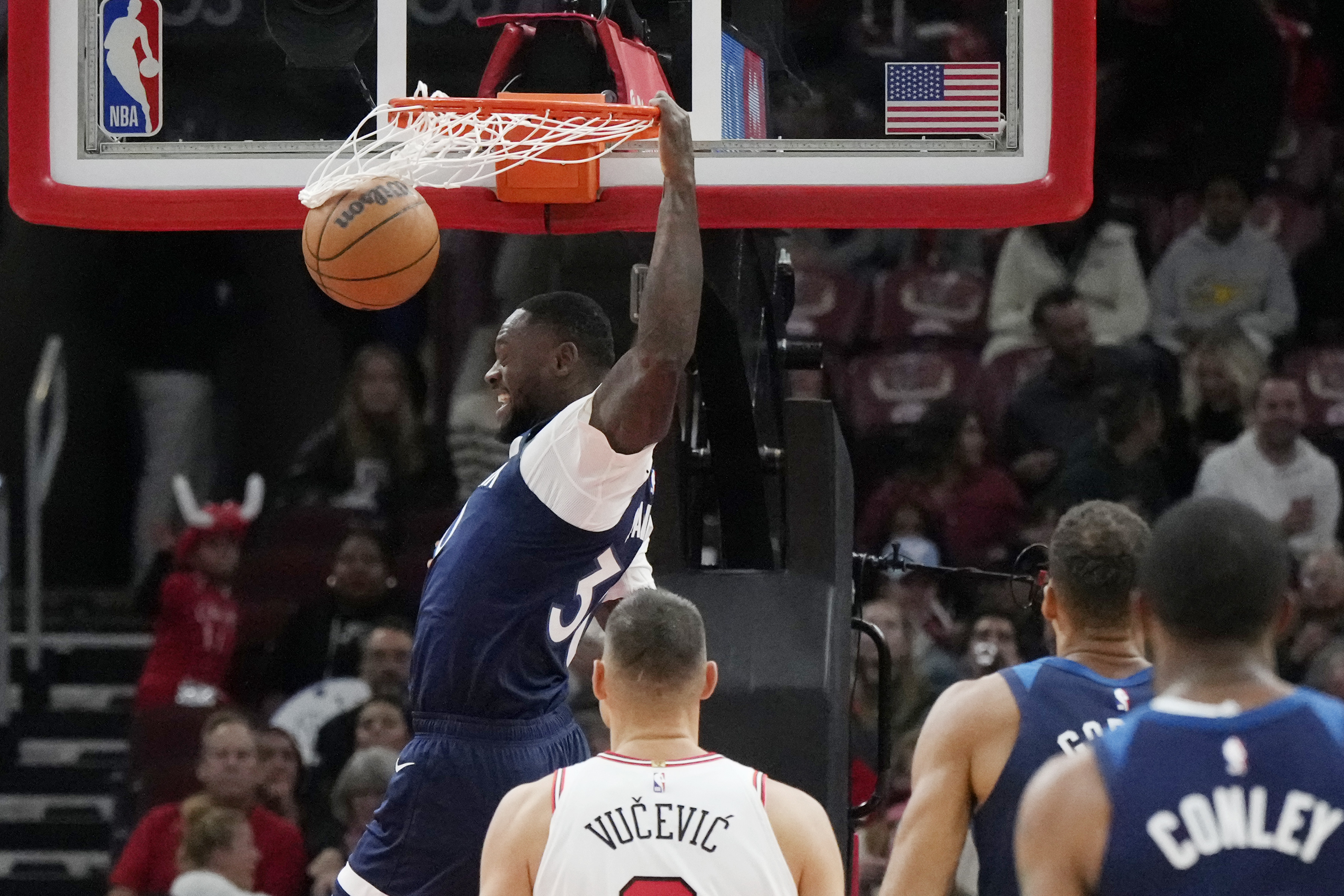 Minnesota Timberwolves forward Julius Randle, top, reacts after dunking during the first half of an NBA preseason basketball game against the Chicago Bulls in Chicago, Wednesday, Oct. 16, 2024.