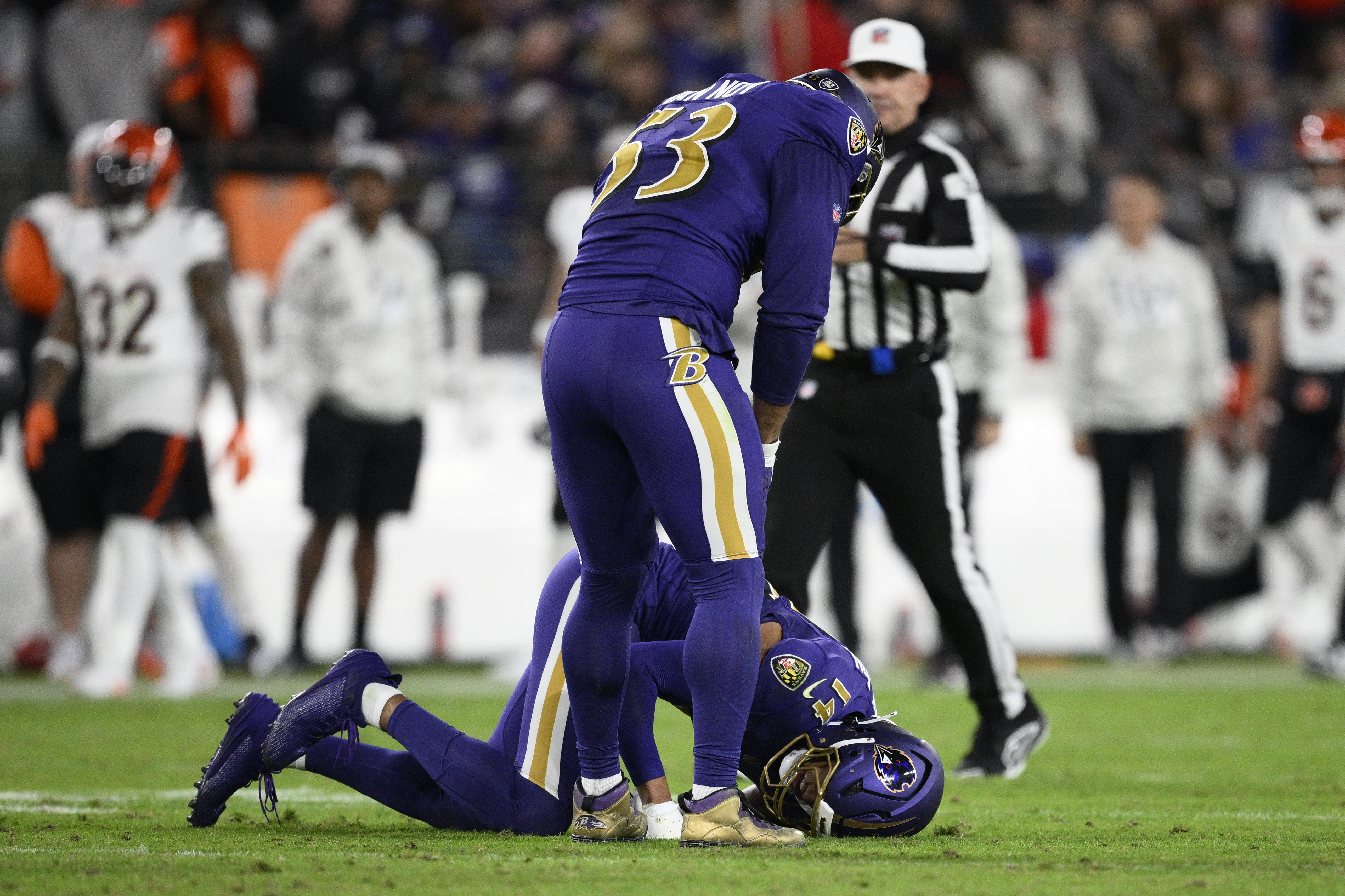 Baltimore Ravens safety Kyle Hamilton (14) is injured as linebacker Kyle Van Noy (53) stands over him during the first half of an NFL football game against the Cincinnati Bengals, Thursday, Nov. 7, 2024, in Baltimore.