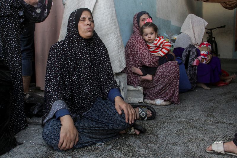 Palestinians react after a school sheltering displaced people was hit by an Israeli strike, at Beach camp in Gaza City, Thursday. Women and children were nearly 70% of confirmed dead in Gaza, a report finds.