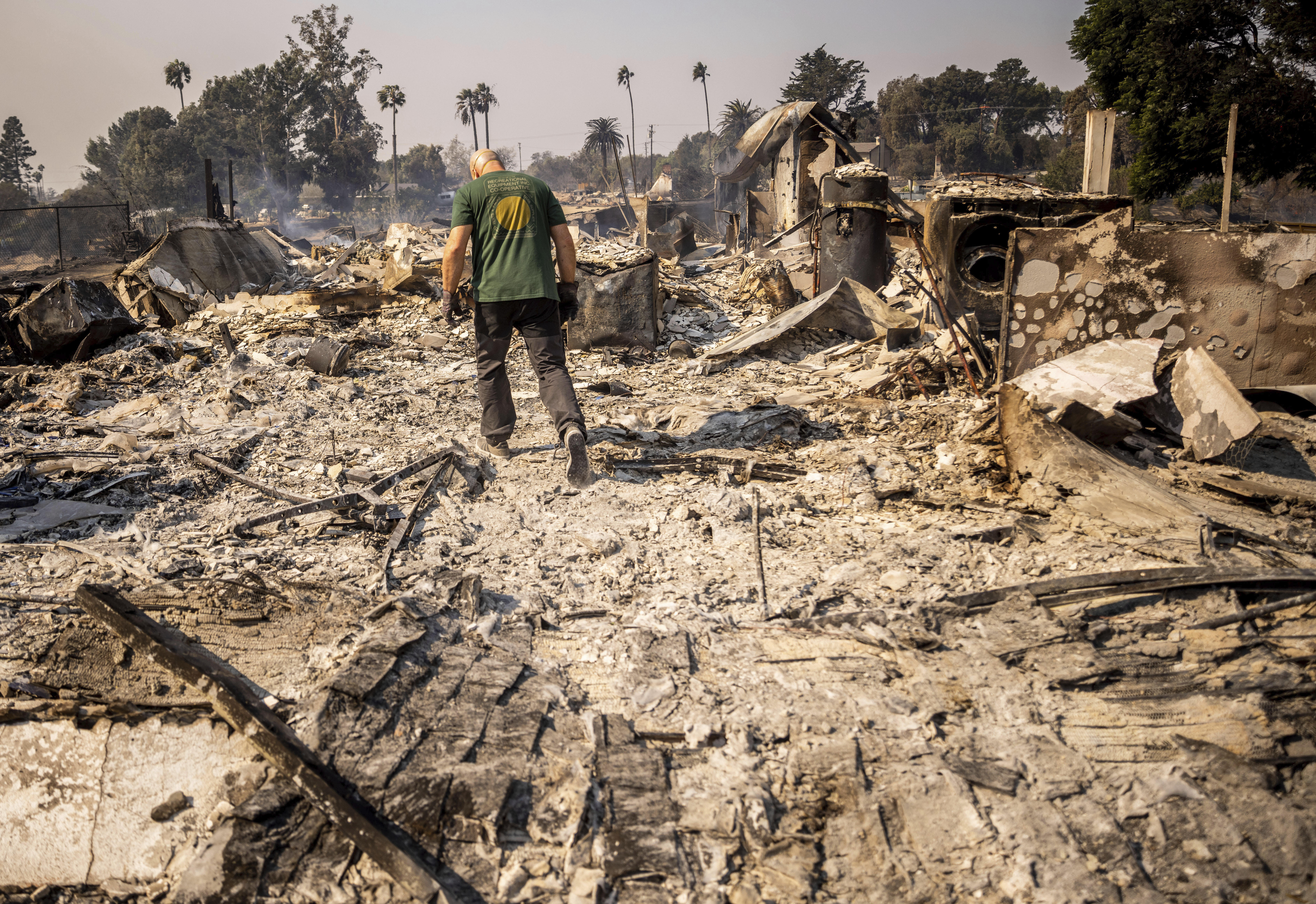 Marvin Meador walks on the remains of his fire-ravaged property after the Mountain Fire swept through, Thursday, in Camarillo, Calif.