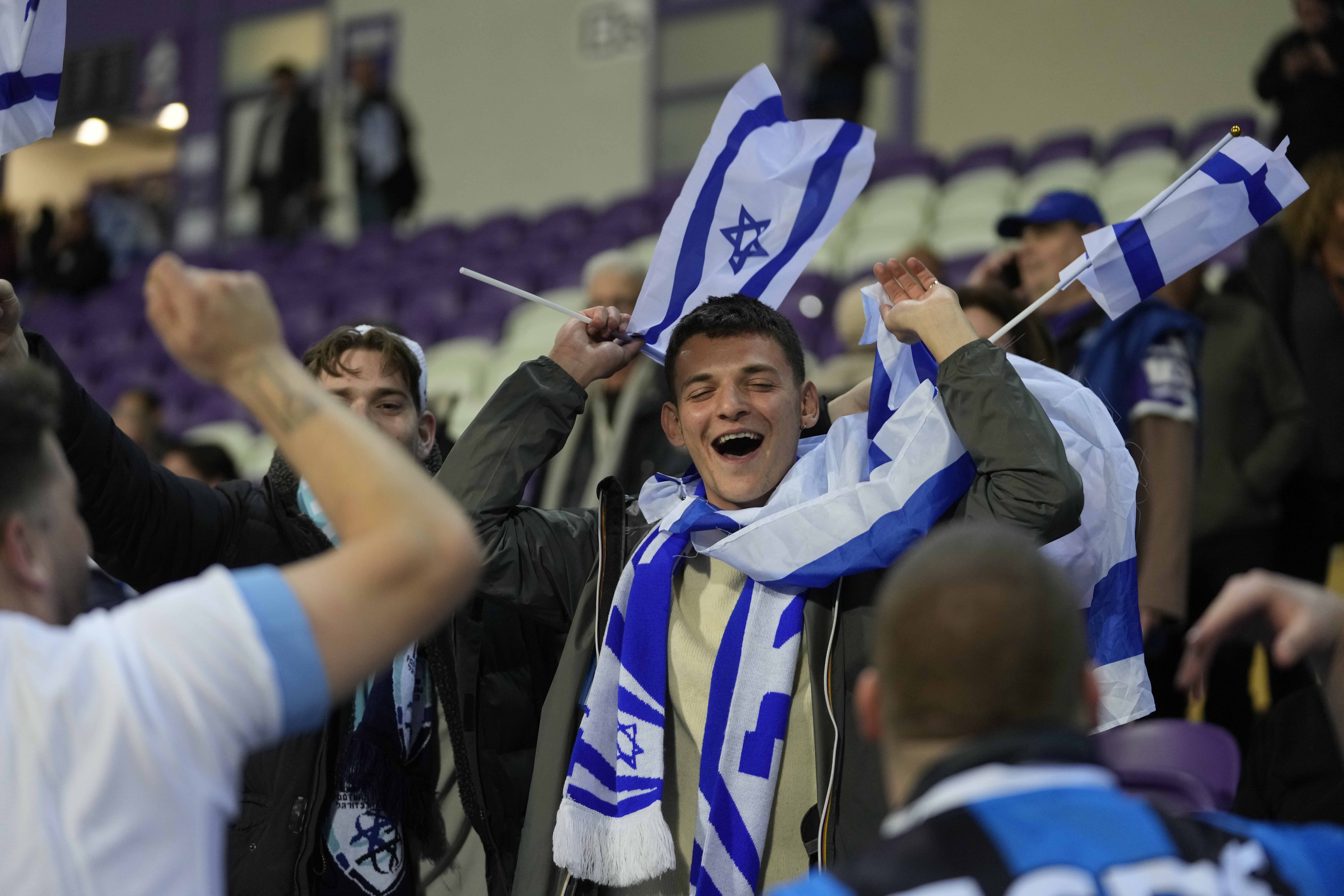 FILE - Israel supporters wave flags during the Euro 2024 qualifying play-off soccer match between Israel and Iceland, at Szusza Ferenc Stadium in Budapest, Hungary, Thursday, March 21, 2024.