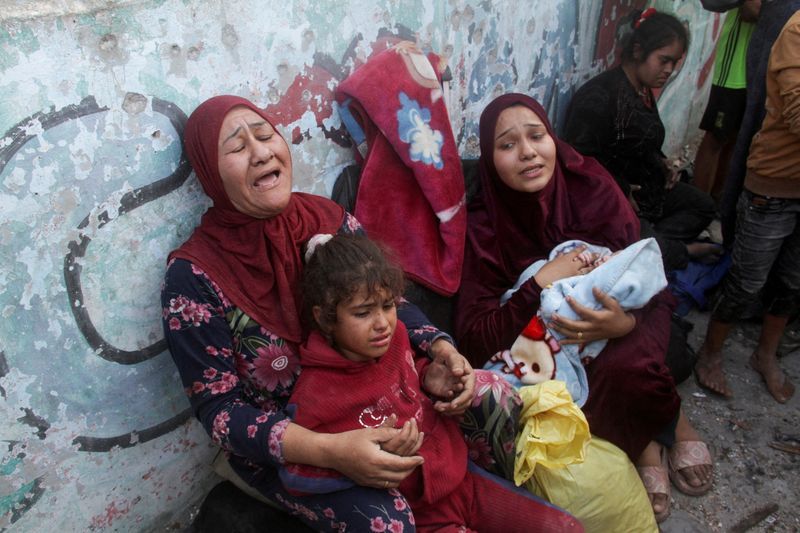 Palestinians react after a school sheltering displaced people was hit by an Israeli strike, at Beach camp in Gaza City, Thursday.