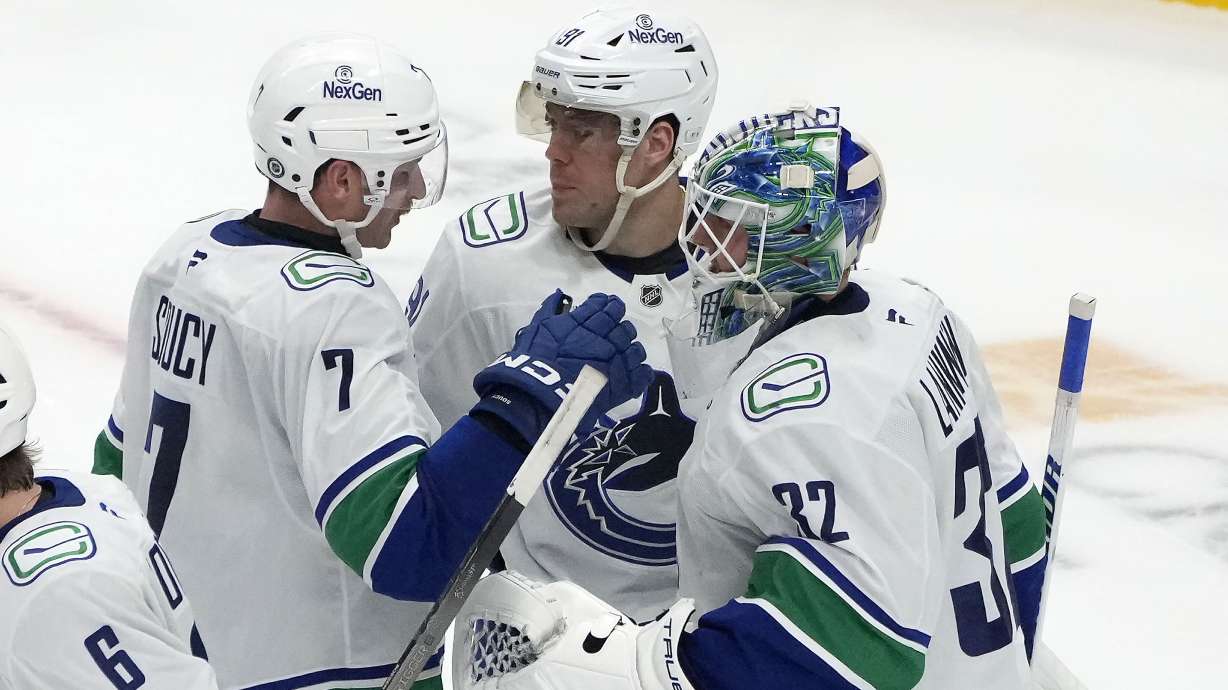 Vancouver Canucks goaltender Kevin Lankinen (32) is congratulated by Daniel Sprong, center, and Carson Soucy (7) after defeating the San Jose Sharks in an NHL hockey game in San Jose, Calif., Saturday, Nov. 2, 2024.