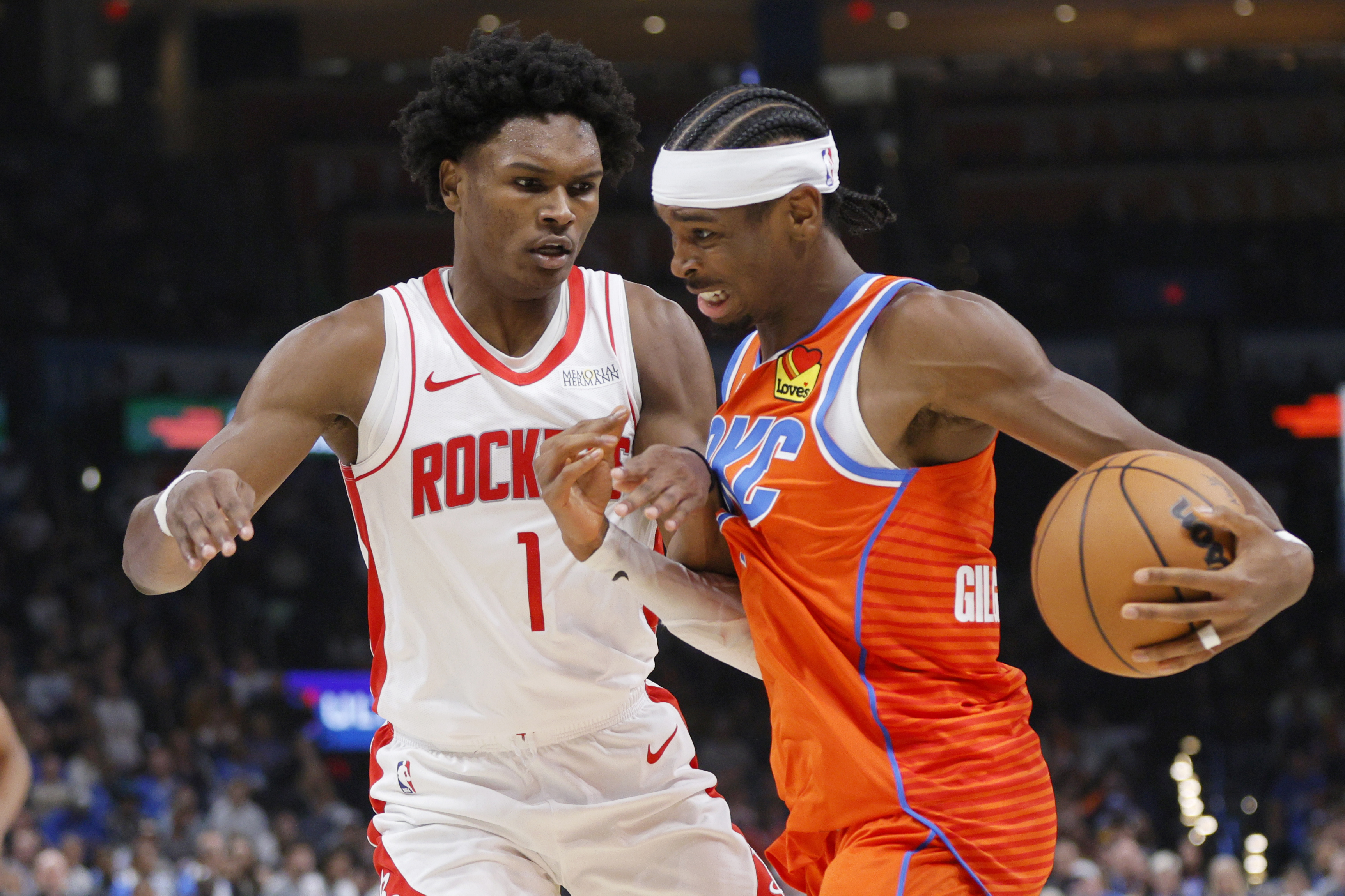 Oklahoma City Thunder guard Shai Gilgeous-Alexander, right, drives against Houston Rockets forward Amen Thompson (1) during the first half of an NBA basketball game Friday, Nov. 8, 2024, in Oklahoma City.