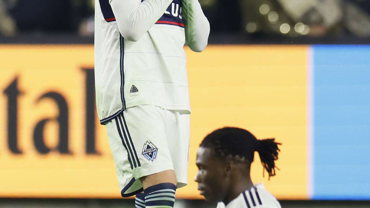 Vancouver Whitecaps' Tristan Blackmon, left, reacts next to Vancouver Whitecaps' Samuel Adekugbe after his team lost against the Los Angeles FC in a first-round MLS Cup playoffs soccer match, Friday, Nov. 8, 2024, in Los Angeles.