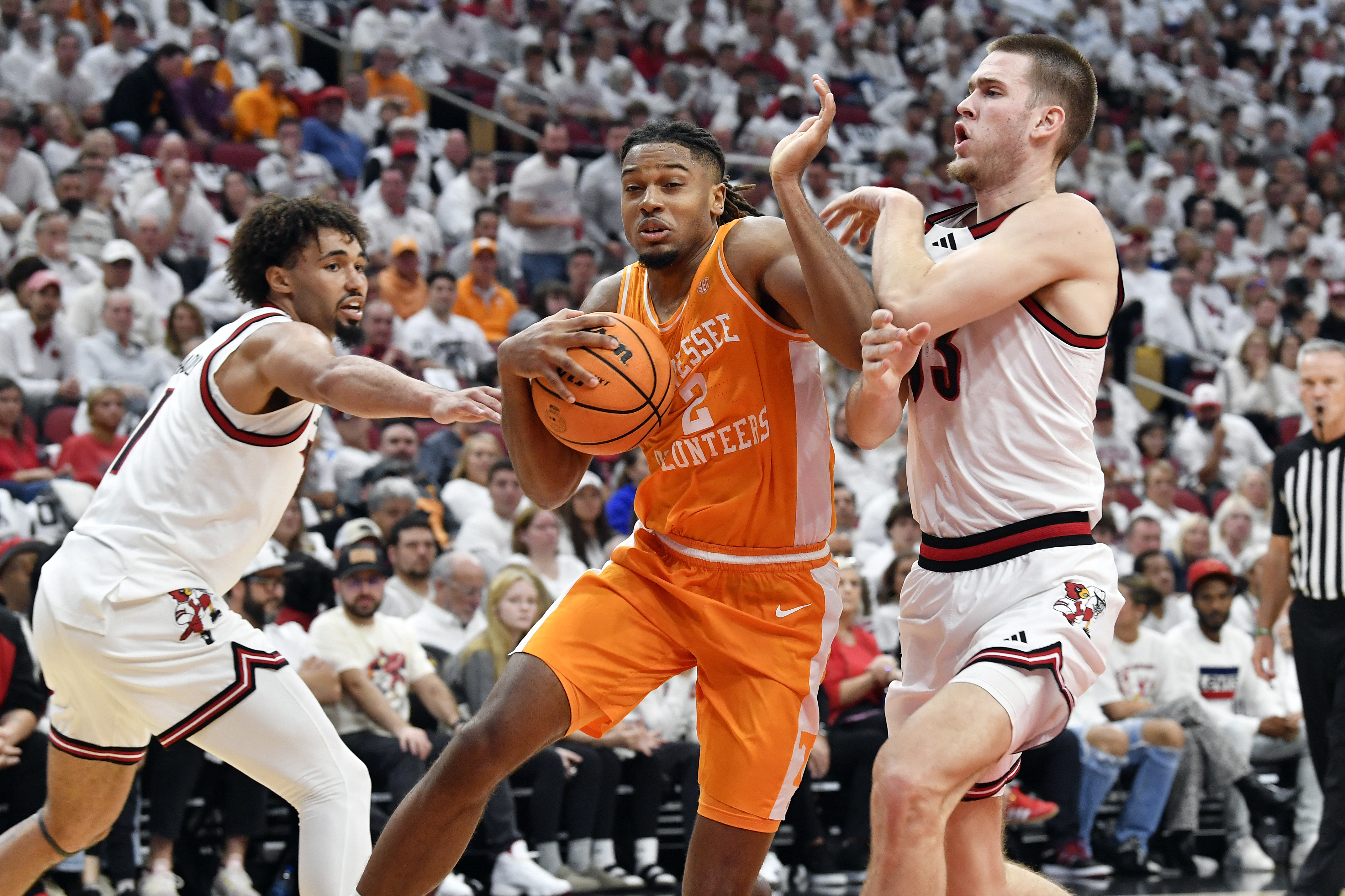 Tennessee guard Chaz Lanier (2) fights through the defense of Louisville guard J'Vonne Hadley (1), left, and forward Noah Waterman (93) during the first half of an NCAA college basketball game in Louisville, Ky., Saturday, Nov. 9, 2024.