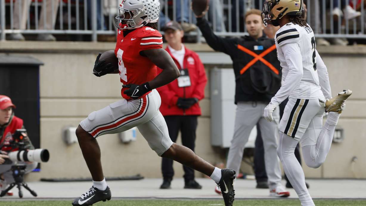 Ohio State receiver Jeremiah Smith, left, runs past Purdue defensive back Nyland Green to score a touchdown during the first half of an NCAA college football game Saturday, Nov. 9, 2024, in Columbus, Ohio.