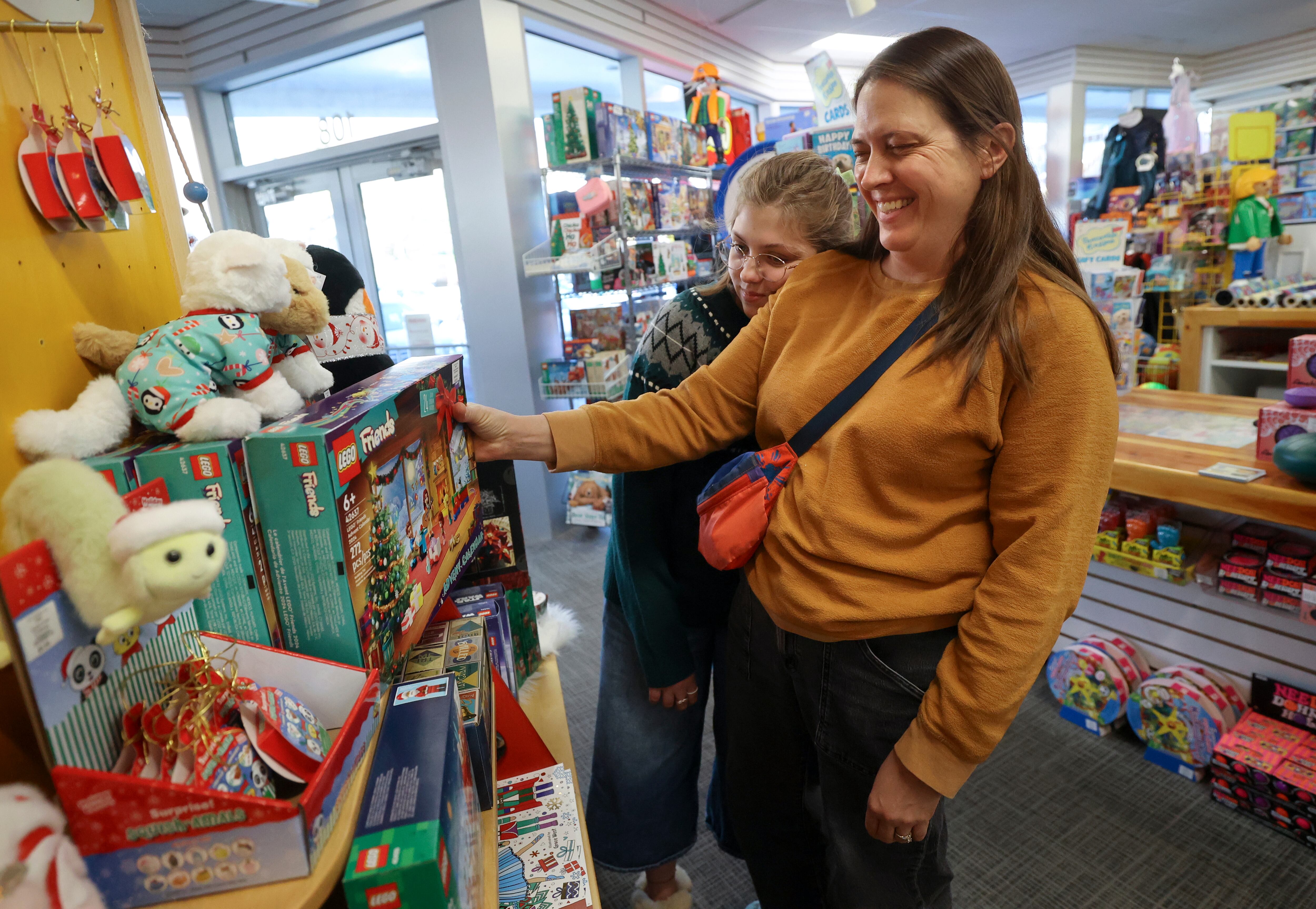 Ruby Gygi rests her head on her mother Gentry Gigi’s shoulder as they browse for holiday shopping ideas at Tutoring Toy in Salt Lake City on Nov. 7.