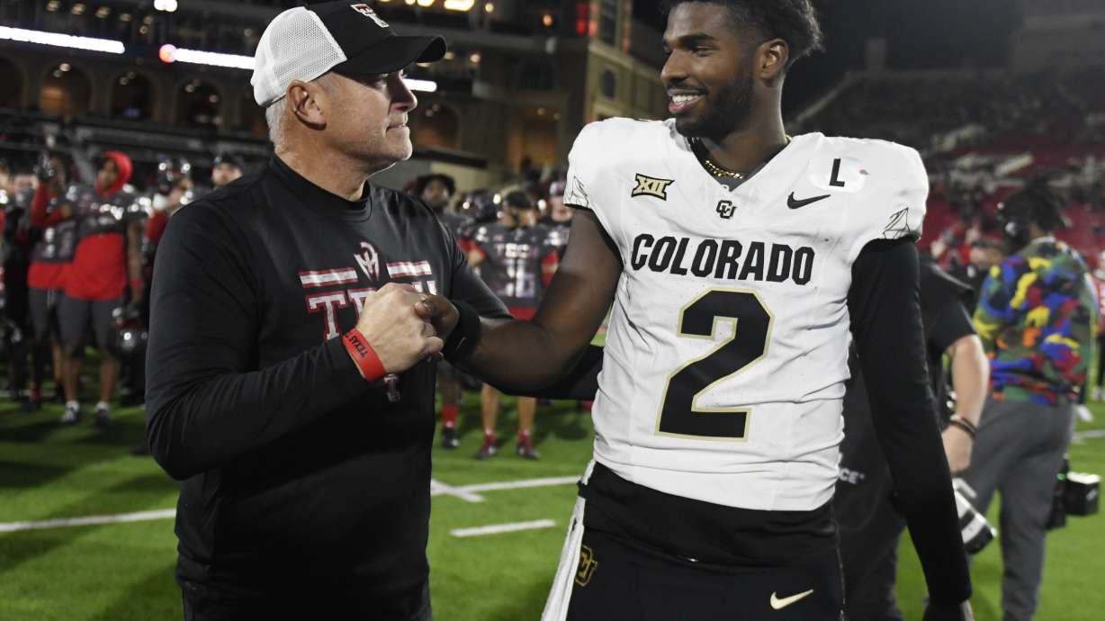 Texas Tech's head coach Joey McGuire, left, and Colorado's quarterback Shedeur Sanders (2) shake hands after the NCAA college football game, Saturday, Nov. 9, 2024, in Lubbock, Texas.