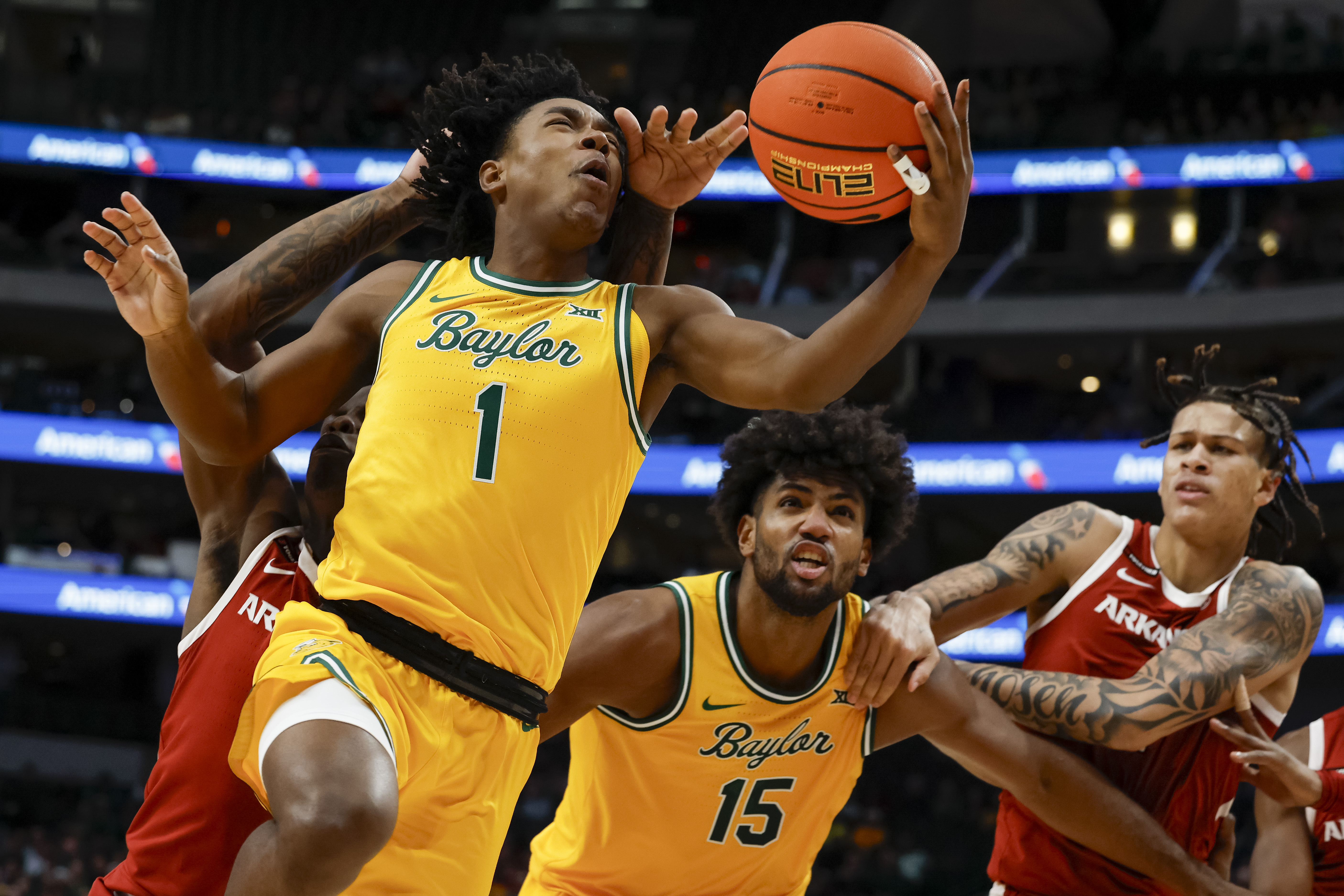 Baylor guard Robert Wright III (1) scores as he is fouled by Arkansas guard Johnell Davis, back left, during the first half of an NCAA college basketball game, Saturday, Nov. 9, 2024, in Dallas. 