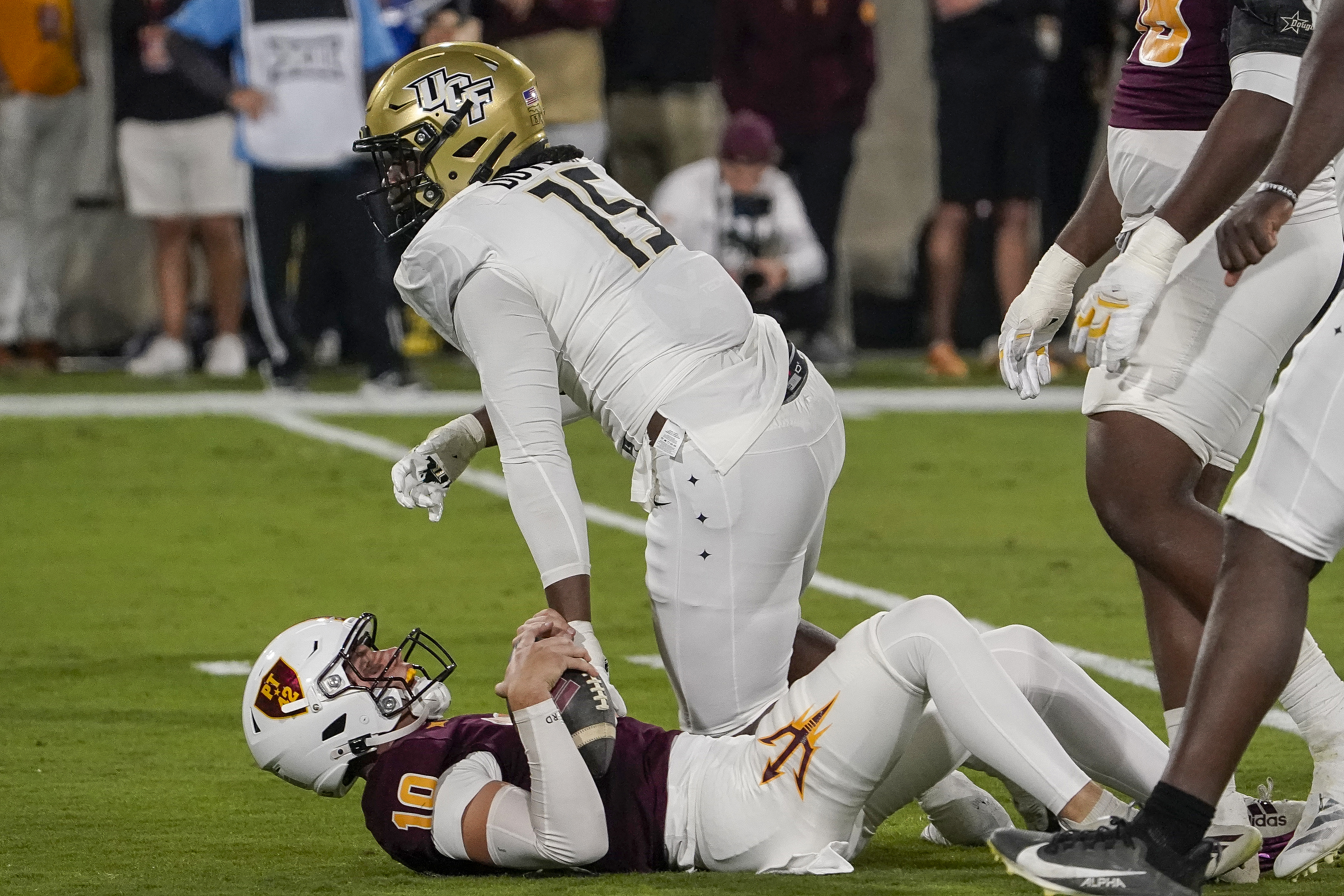 Arizona State quarterback Sam Leavitt (10) grimaces after being sacked by Central Florida defensive end Daylan Dotson (15) during the first half of an NCAA college football game Saturday, Nov. 9, 2024, in Tempe, Ariz.