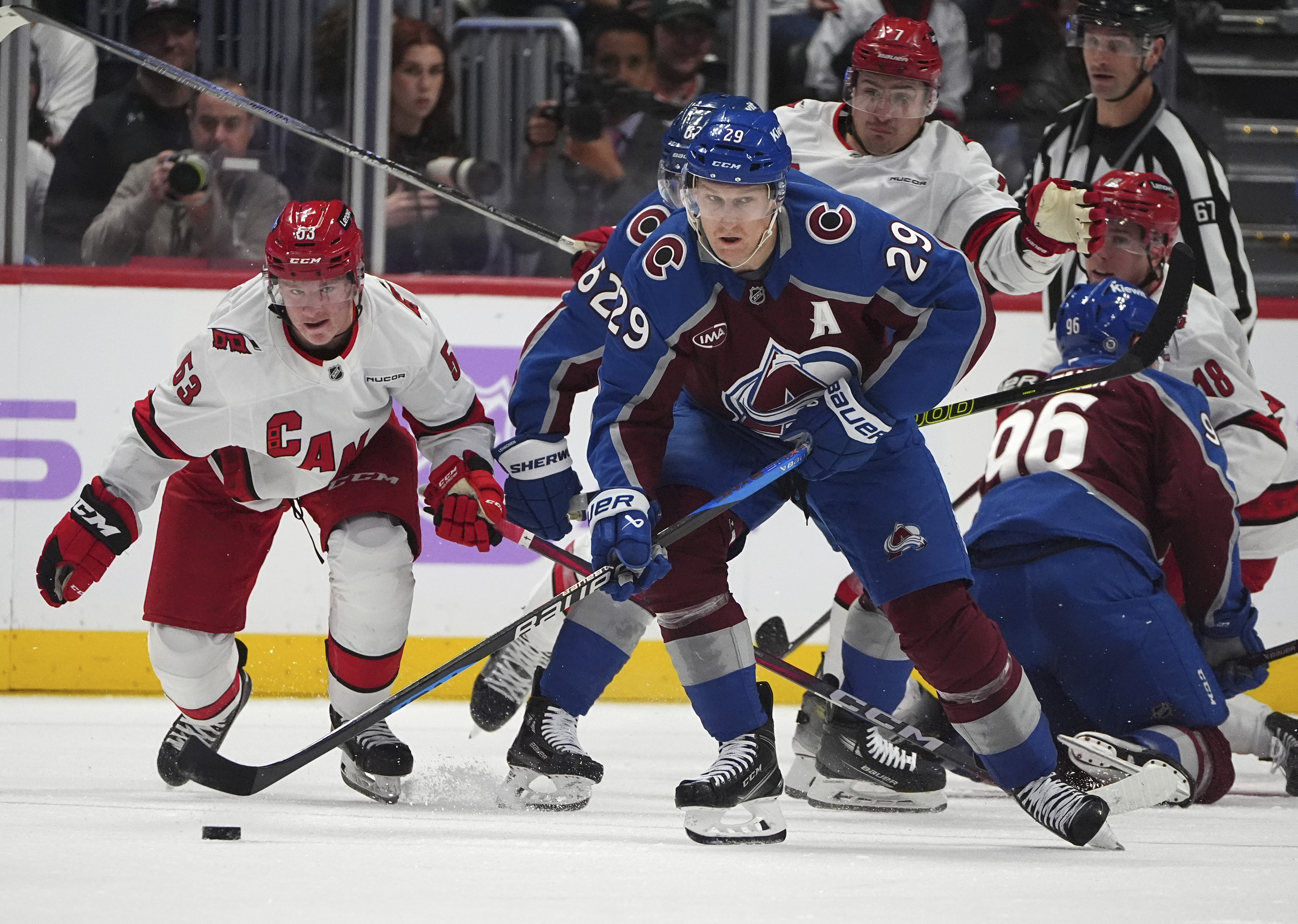Colorado Avalanche center Nathan MacKinnon, right, collects the puck as Carolina Hurricanes right wing Jackson Blake defends in the second period of an NHL hockey game Saturday, Nov. 9, 2024, in Denver.