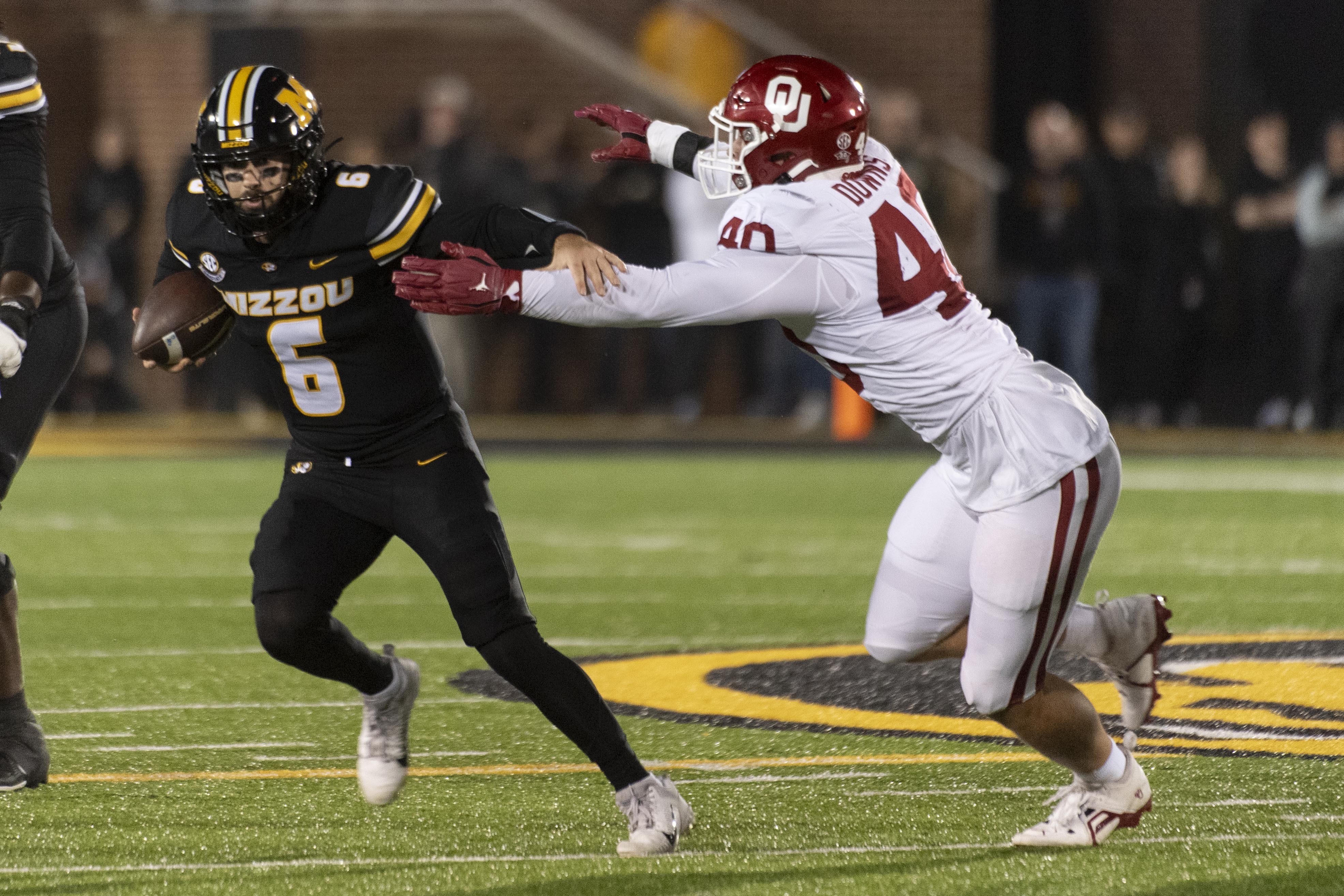 Missouri quarterback Drew Pyne (6) runs from Oklahoma defensive lineman Ethan Downs during the first half of an NCAA college football game Saturday, Nov. 9, 2024, in Columbia, Mo. 