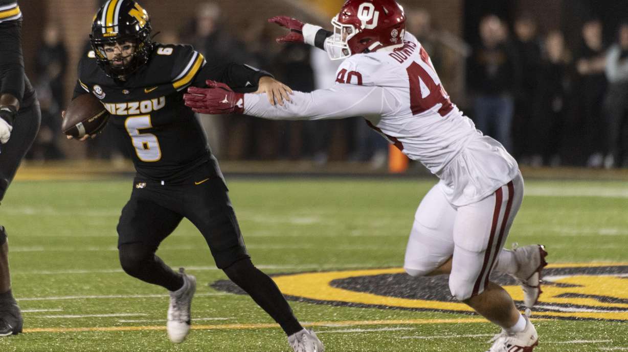 Missouri quarterback Drew Pyne (6) runs from Oklahoma defensive lineman Ethan Downs during the first half of an NCAA college football game Saturday, Nov. 9, 2024, in Columbia, Mo.