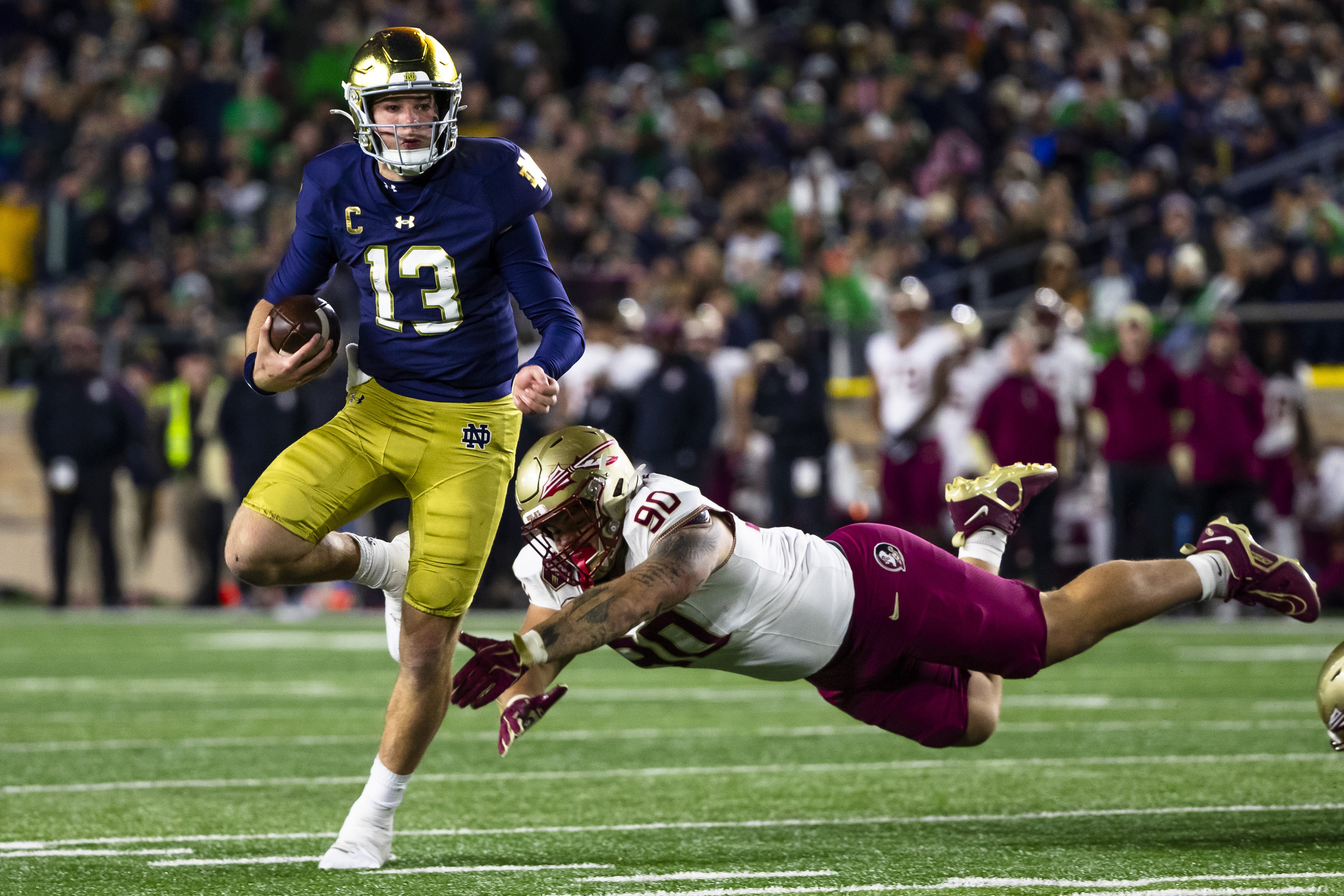 Notre Dame quarterback Riley Leonard (13) gets away from Florida State defensive lineman Grady Kelly (90) during the second half of an NCAA college football game Saturday, Nov. 9, 2024, in South Bend, Ind.