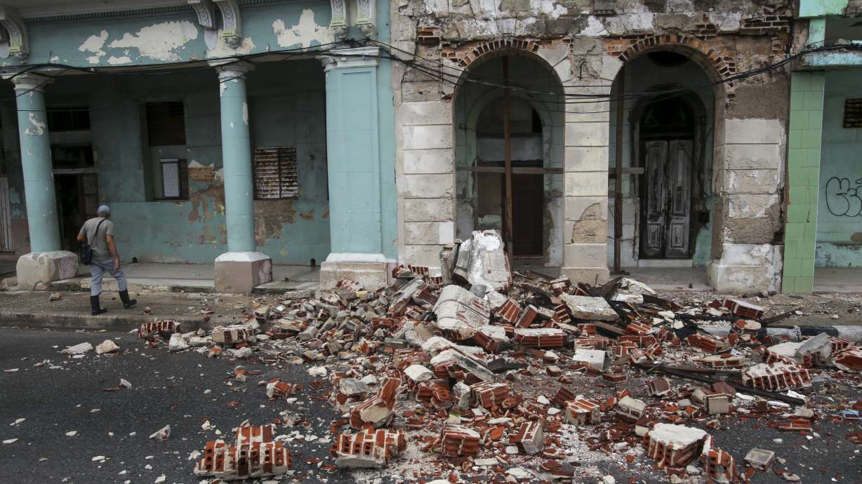 Debris from a building damaged by the passage of Hurricane Rafael covers the street in Havana, Cuba, Thursday. An earthquake with a preliminary magnitude of 6.8 has shaken eastern Cuba after weeks of hurricanes and blackouts that have left many on the island reeling.