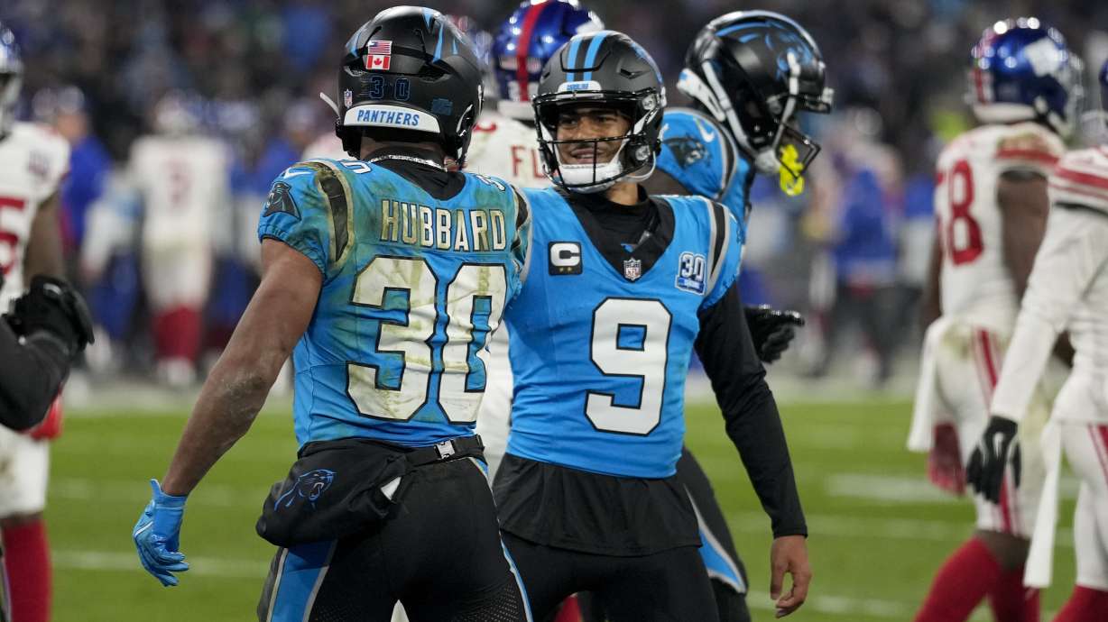 Carolina Panthers running back Chuba Hubbard celebrates his touchdown with quarterback Bryce Young during the second half of an NFL football game against the New York Giants, Sunday, Nov. 10, 2024, in Munich, Germany.