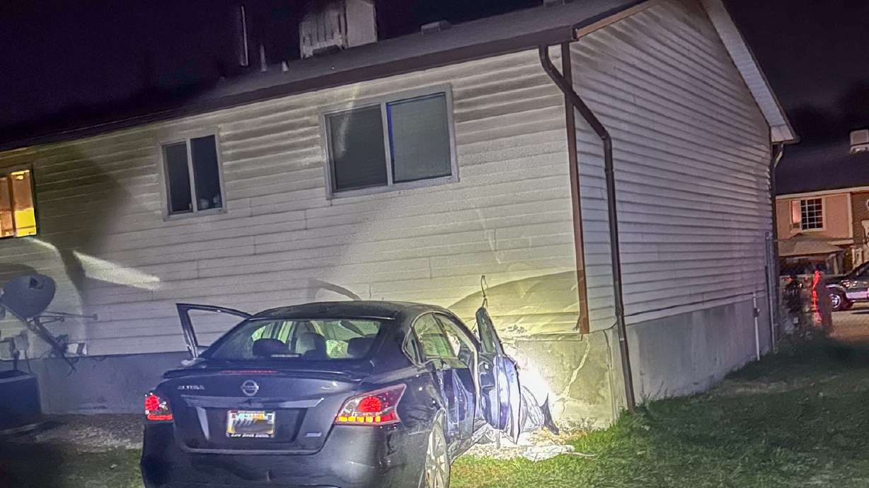 A 27-year-old woman was taken into custody by Salt Lake police and accused of crashing her car into a house on Sunday.