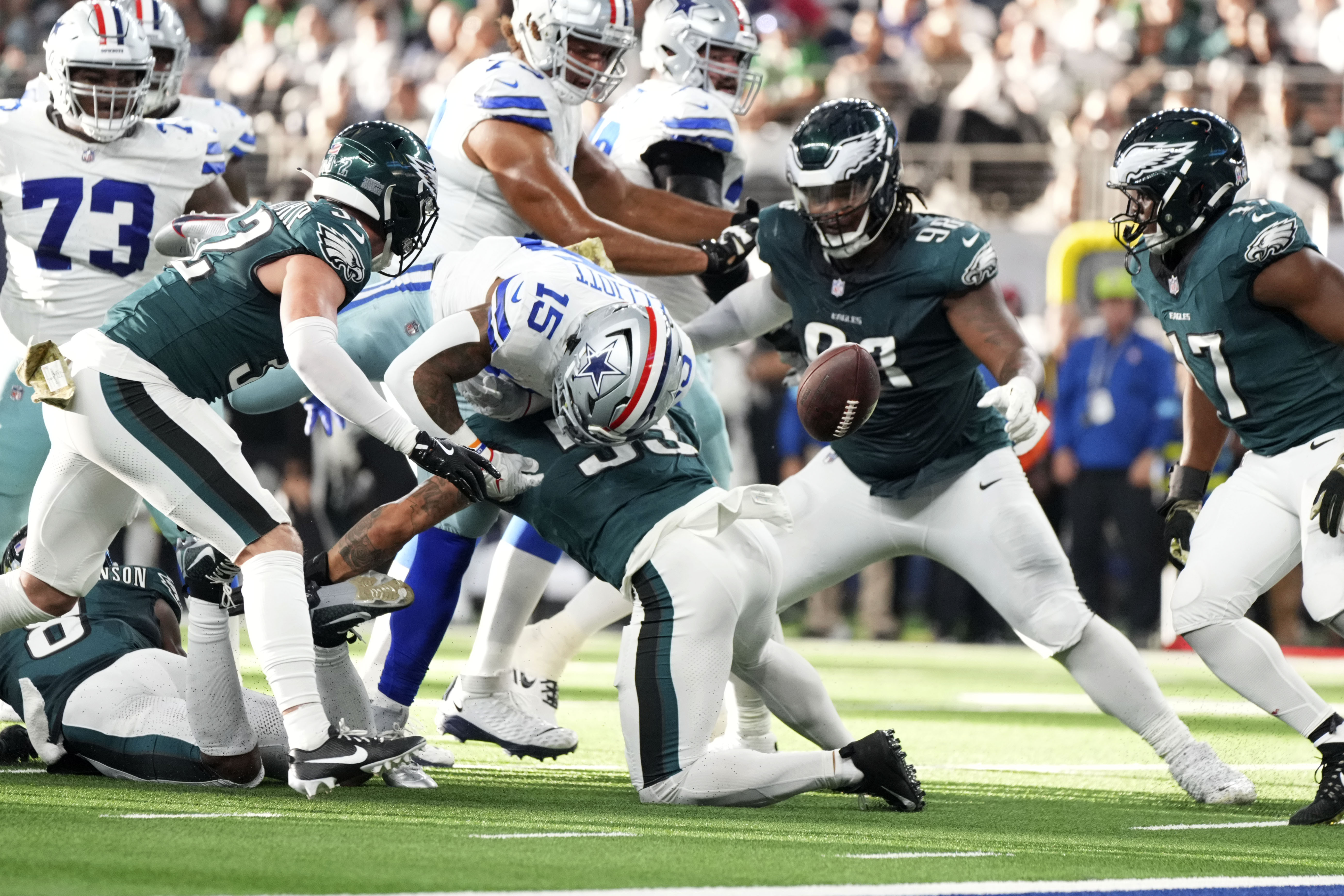 Dallas Cowboys running back Ezekiel Elliott (15) fumbles the ball as he's hit by Philadelphia Eagles linebacker Zack Baun (53) in the first half of an NFL football game in Arlington, Texas, Sunday, Nov. 10, 2024.