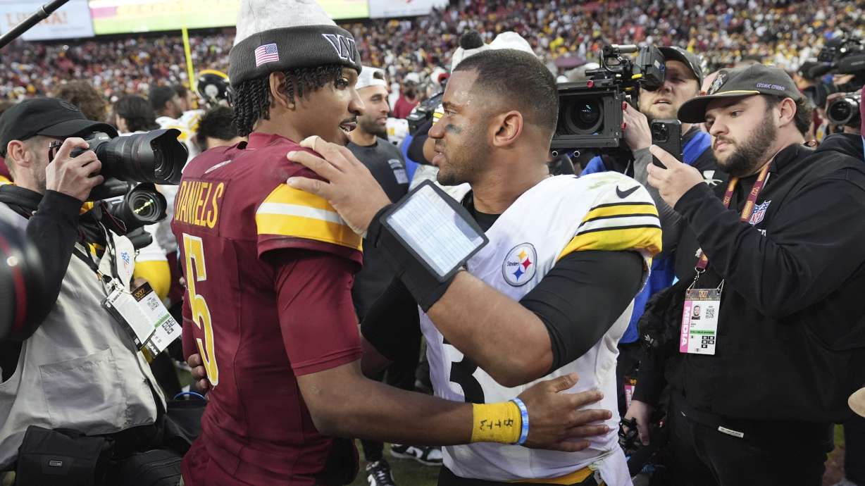 Washington Commanders quarterback Jayden Daniels (5) hugs Pittsburgh Steelers quarterback Russell Wilson after an NFL football game, Sunday, Nov. 10, 2024, in Landover, Md.