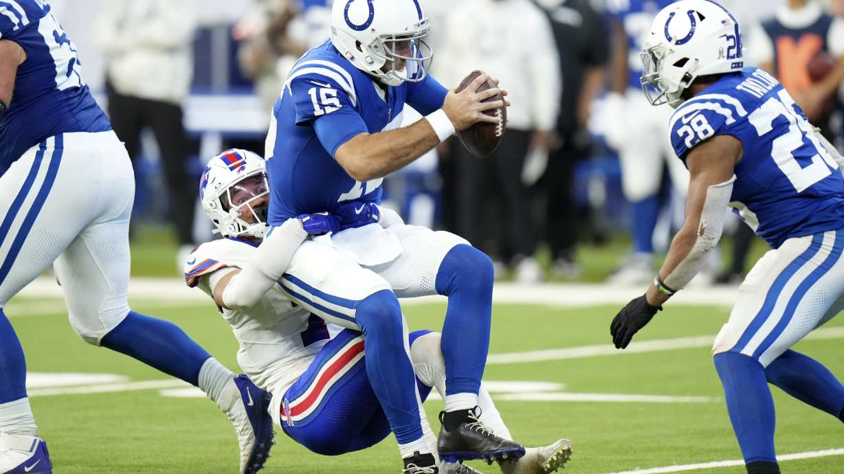 Indianapolis Colts quarterback Joe Flacco (15) is sacked by Buffalo Bills cornerback Taron Johnson (7) during the second half of an NFL football game, Sunday, Nov. 10, 2024, in Indianapolis.