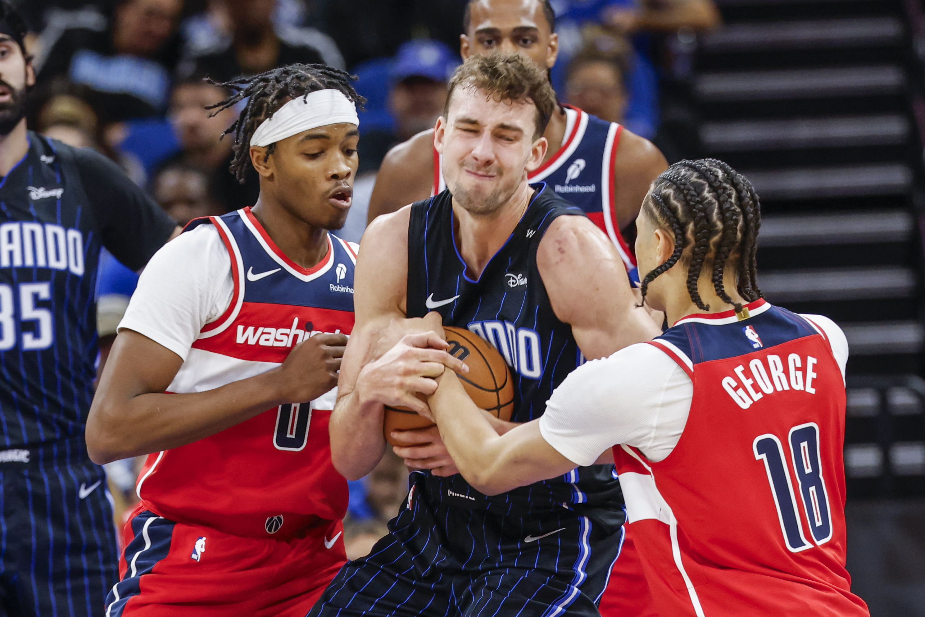 Washington Wizards guard Bilal Coulibaly (0) and teammate forward Kyshawn George (18) fight for ball with Orlando Magic forward Franz Wagner, center front, during the first half of an NBA basketball game, Sunday, Nov. 10, 2024, in Orlando, Fla.
