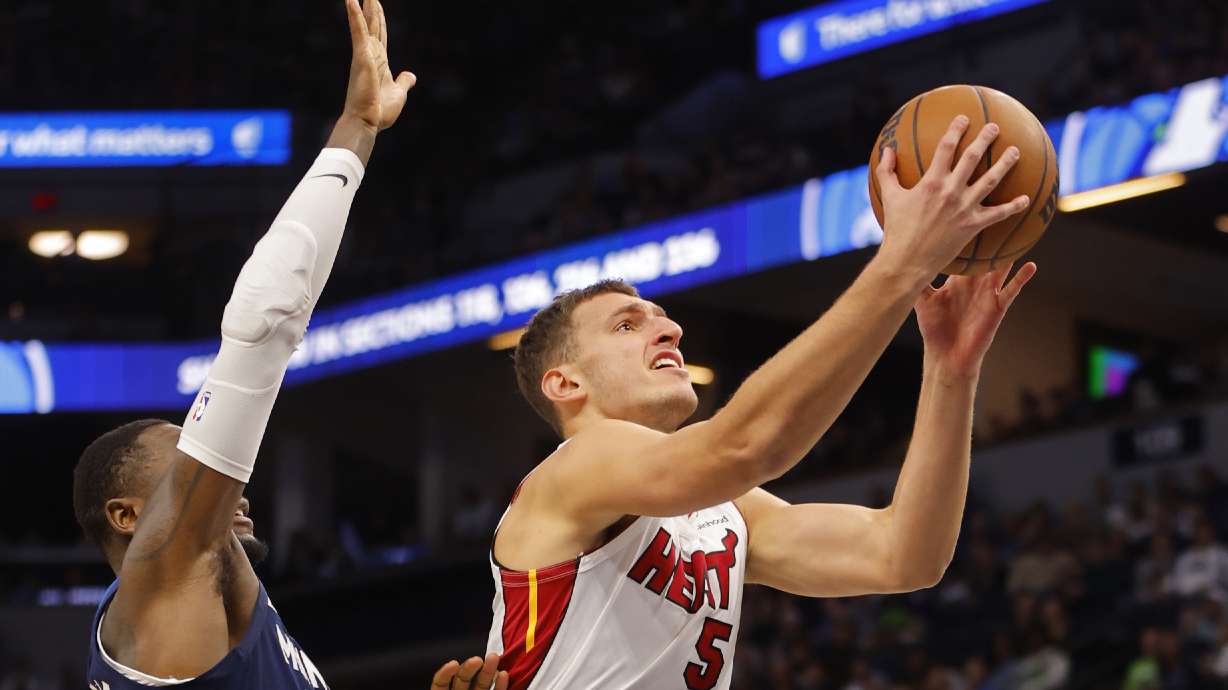Miami Heat forward Nikola Jovic (5) goes to the basket past Minnesota Timberwolves forward Julius Randle, left, in the first quarter of an NBA basketball game Sunday, Nov. 10, 2024, in Minneapolis.