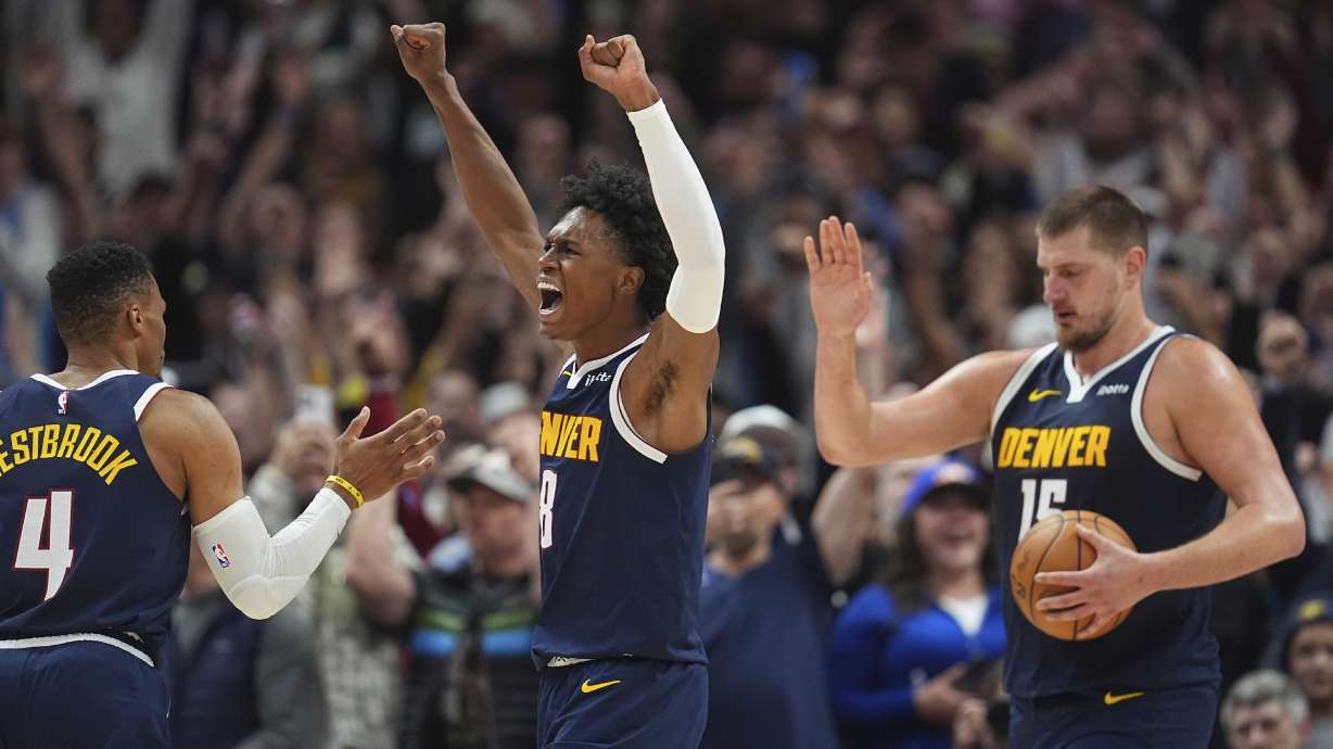 Denver Nuggets forward Peyton Watson, center, celebrates with guard Russell Westbrook (4) and center Nikola Jokic after Dallas Mavericks guard Kyrie Irving missed a last-second shot as time ran out in the second half of an NBA basketball game Sunday, Nov. 10, 2024, in Denver.