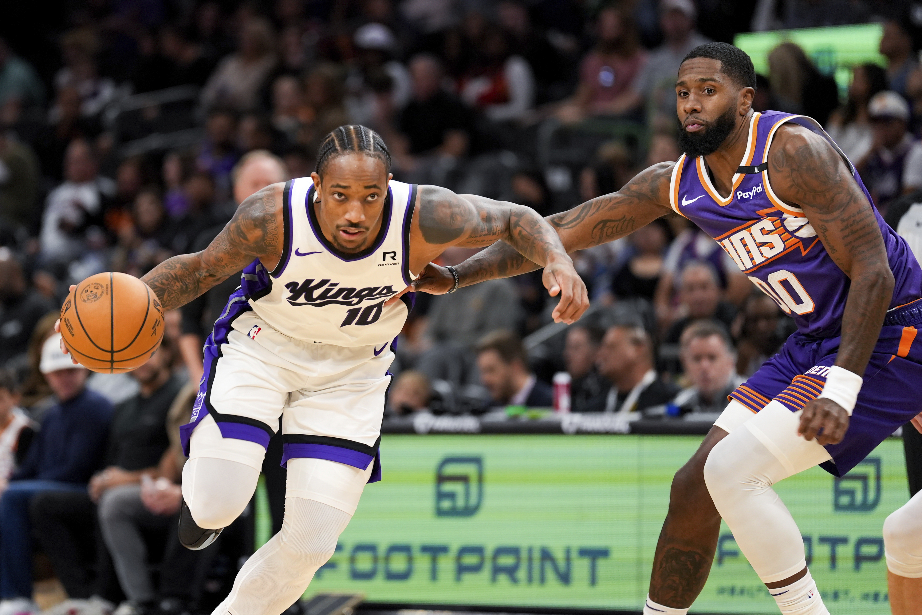 Sacramento Kings forward DeMar DeRozan (10) dribbles past Phoenix Suns forward Ryan Dunn, right, during the first half of an NBA basketball game, Sunday, Nov. 10, 2024, in Phoenix.