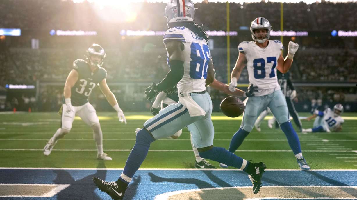 Dallas Cowboys wide receiver CeeDee Lamb runs past a pass thrown into the end zone by quarterback Cooper Rush as Philadelphia Eagles' Cooper DeJean (33) and Jake Ferguson (87) look on in the first half of an NFL football game in Arlington, Texas, Sunday, Nov. 10, 2024.