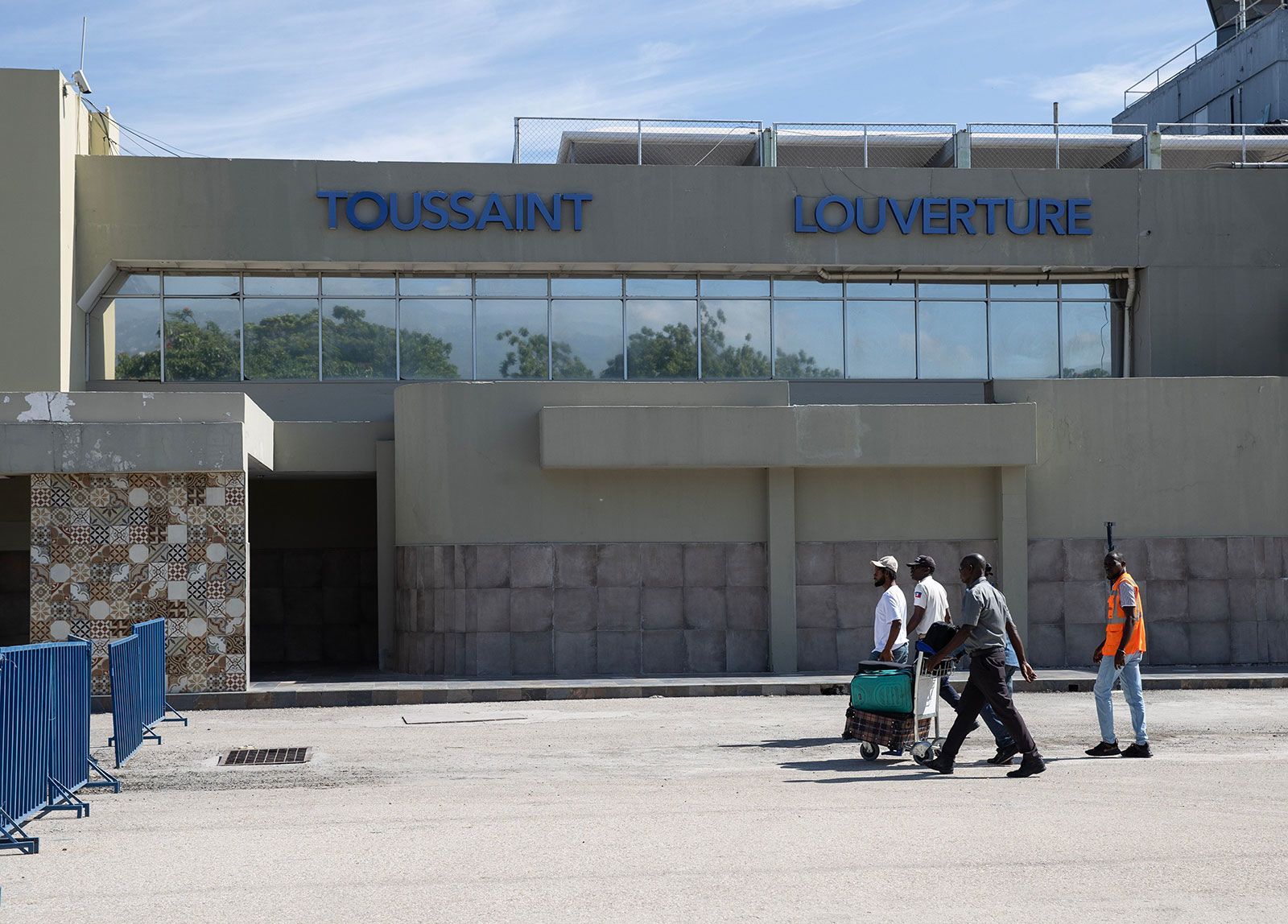 Travelers walk in front of the Toussaint Louverture International Airport in Port-au-Prince in May. Two jets from U.S.-based airlines were struck by bullets on Monday while flying over Port-au-Prince.