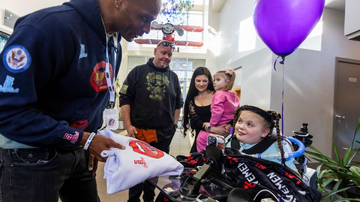 Former Harlem Globetrotter Herb Lang presents Sophia Ostler with a sweatshirt during a proclamation celebration announcing that Ostler’s wish has been selected for fulfillment at the Make-A-Wish Utah headquarters.