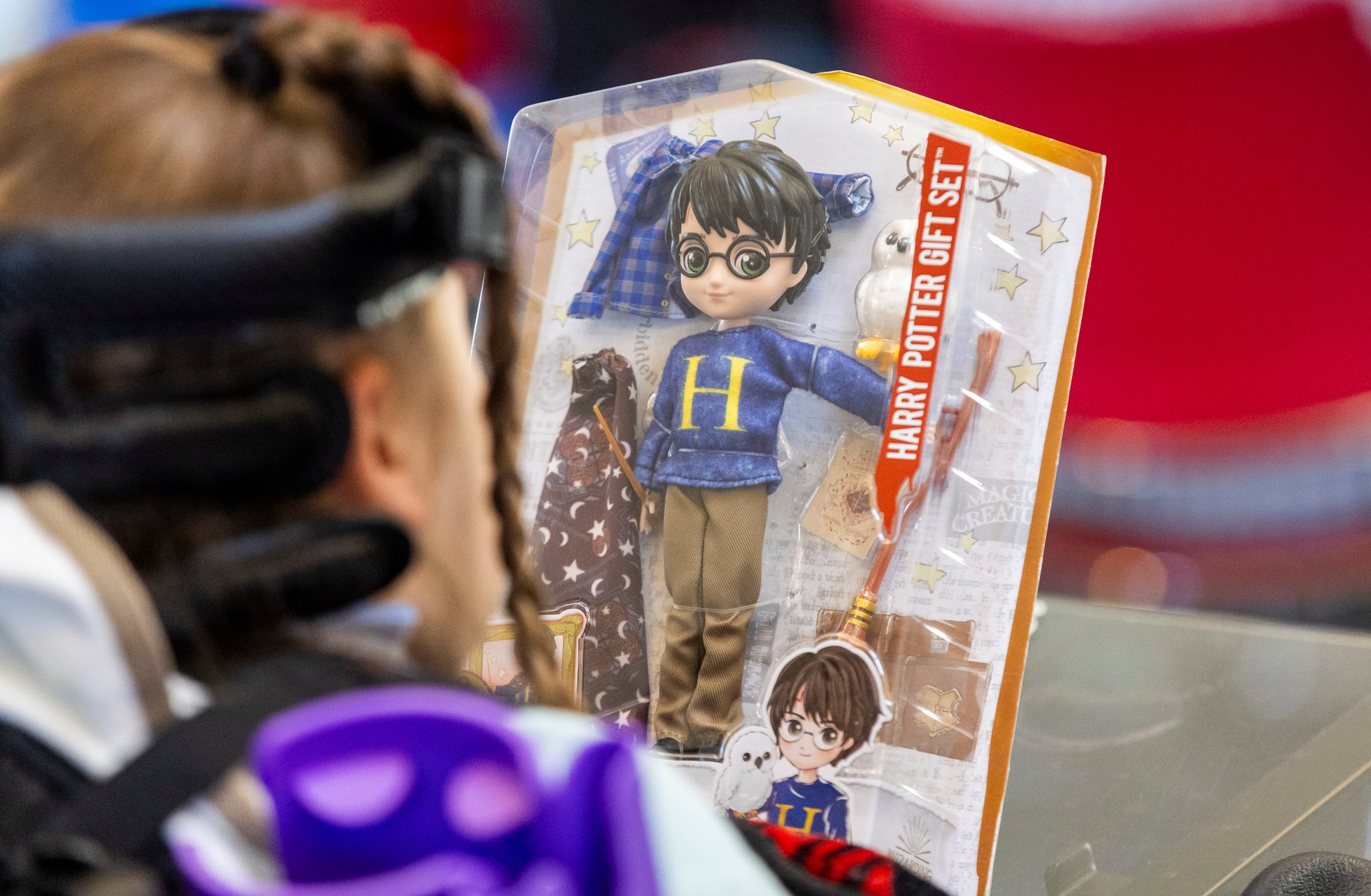 Sophia Ostler admires a Harry Potter doll she received at a proclamation celebration announcing that her wish has been selected for fulfillment at the Make-A-Wish Utah Headquarters in Murray on Monday.